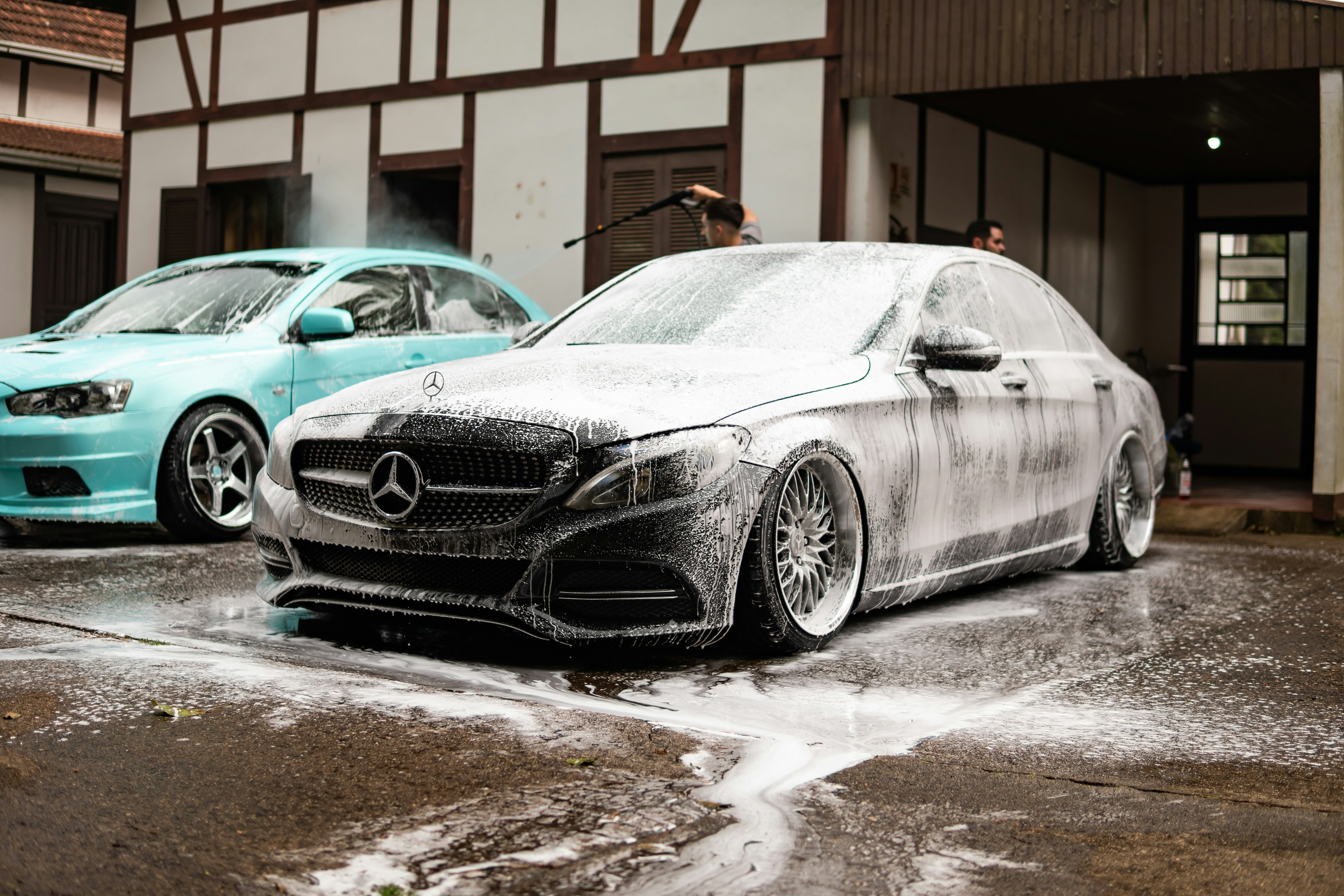 Two cars being washed with foam