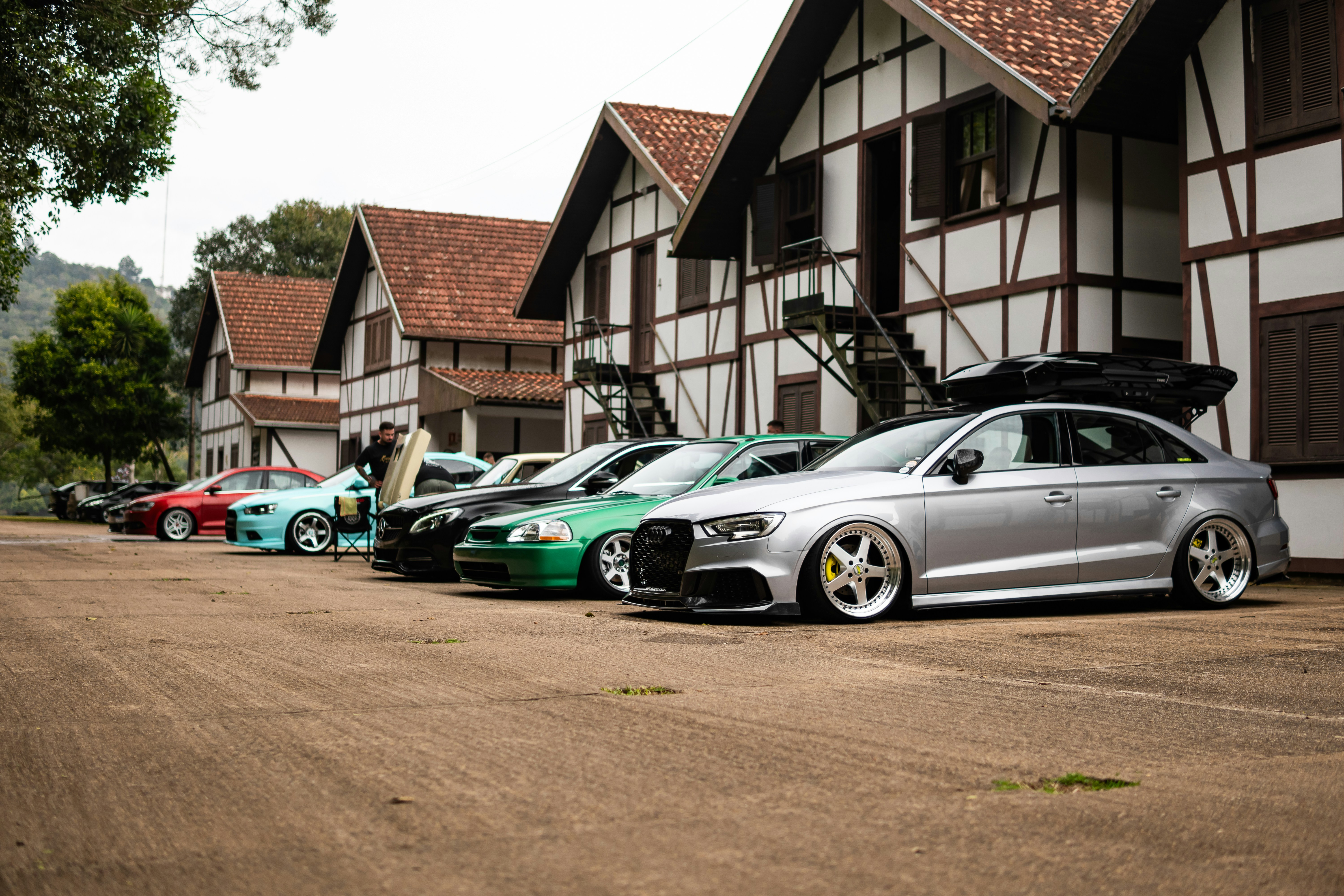 Diverse auto parcheggiate in fila fuori dagli edifici.