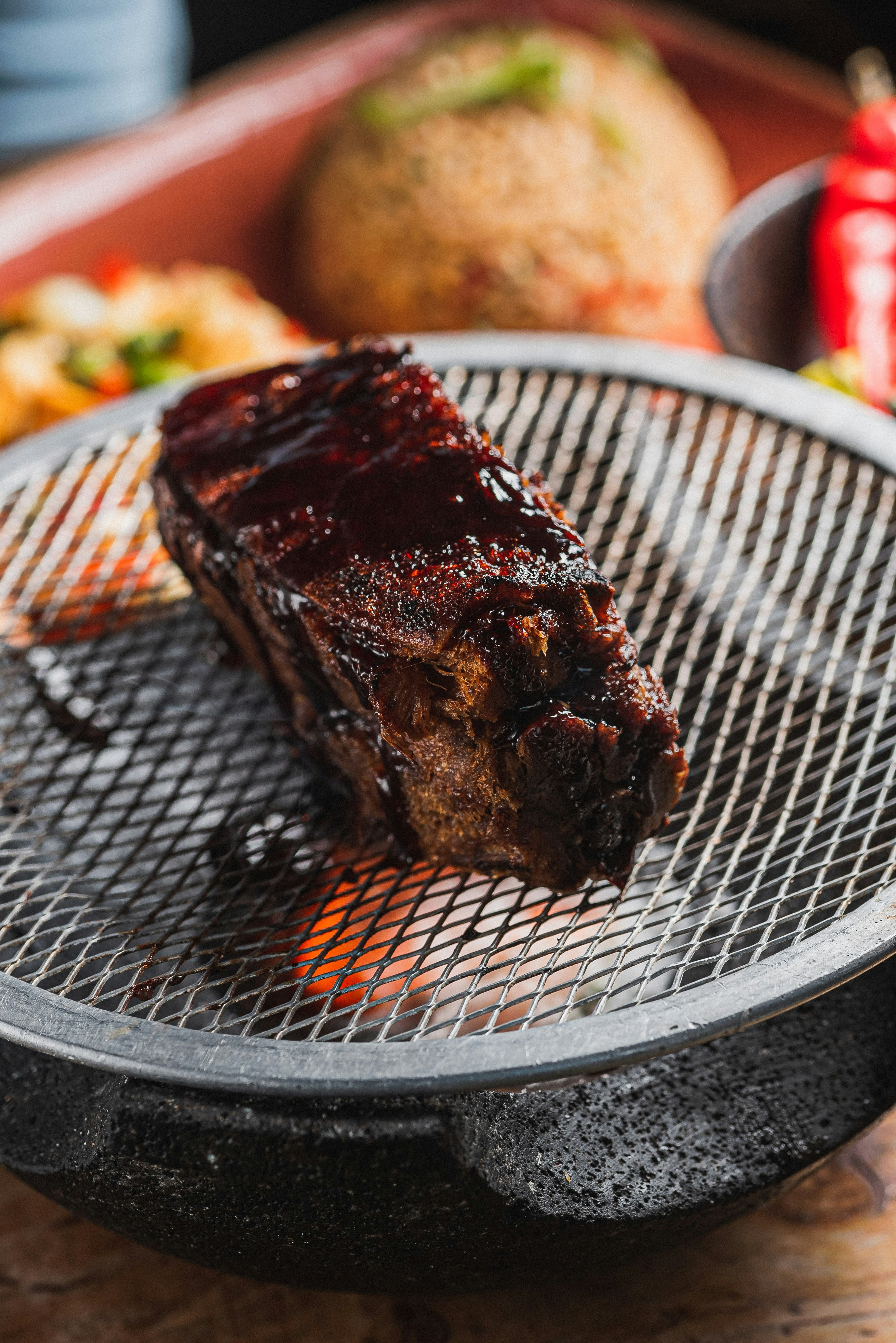 A glazed piece of meat cooking on a grill
