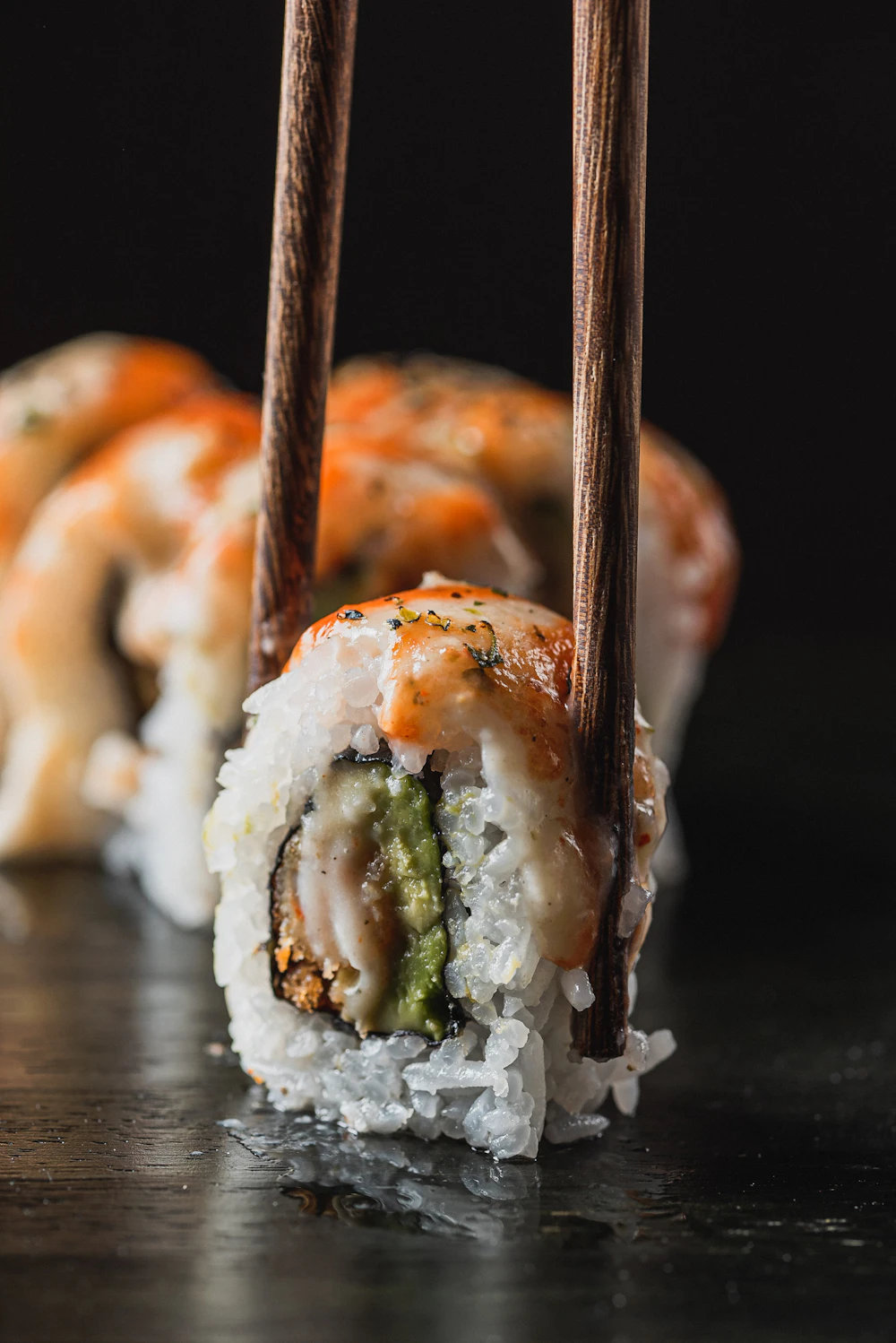 Chopsticks picking up a piece of sushi