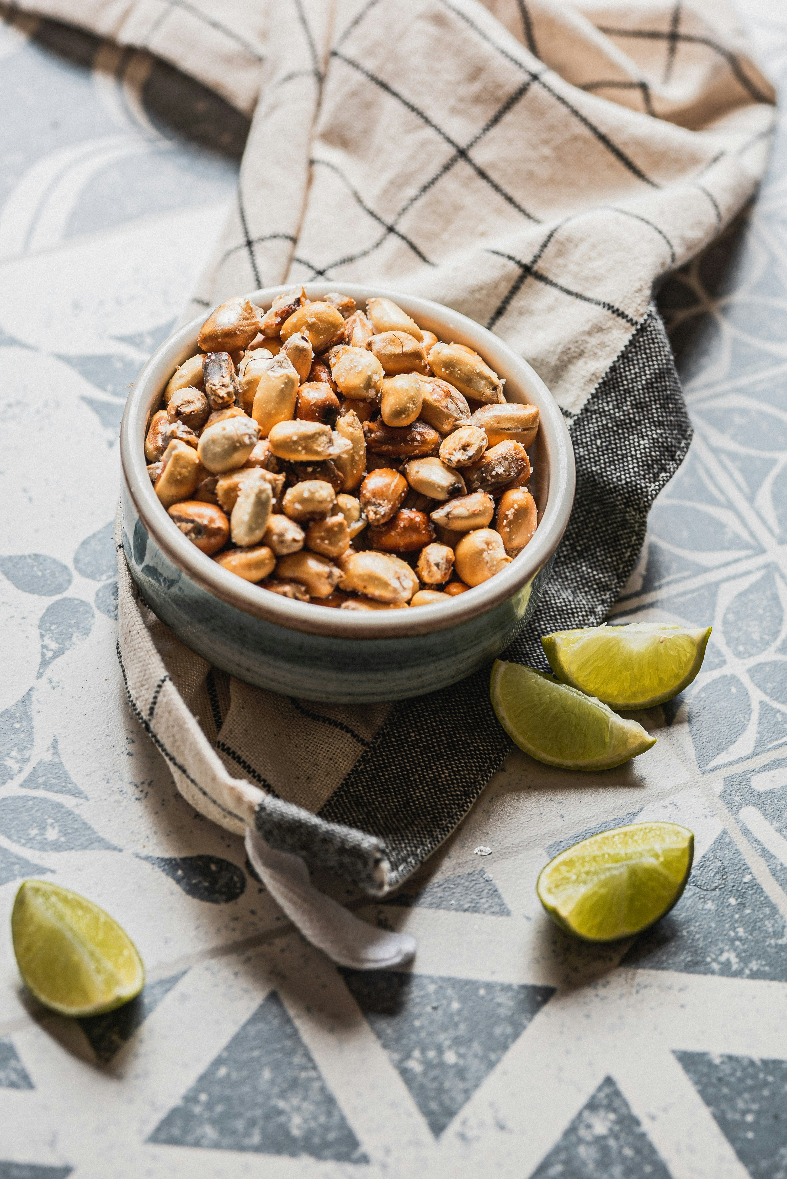 Bowl of toasted corn kernels with lime wedges