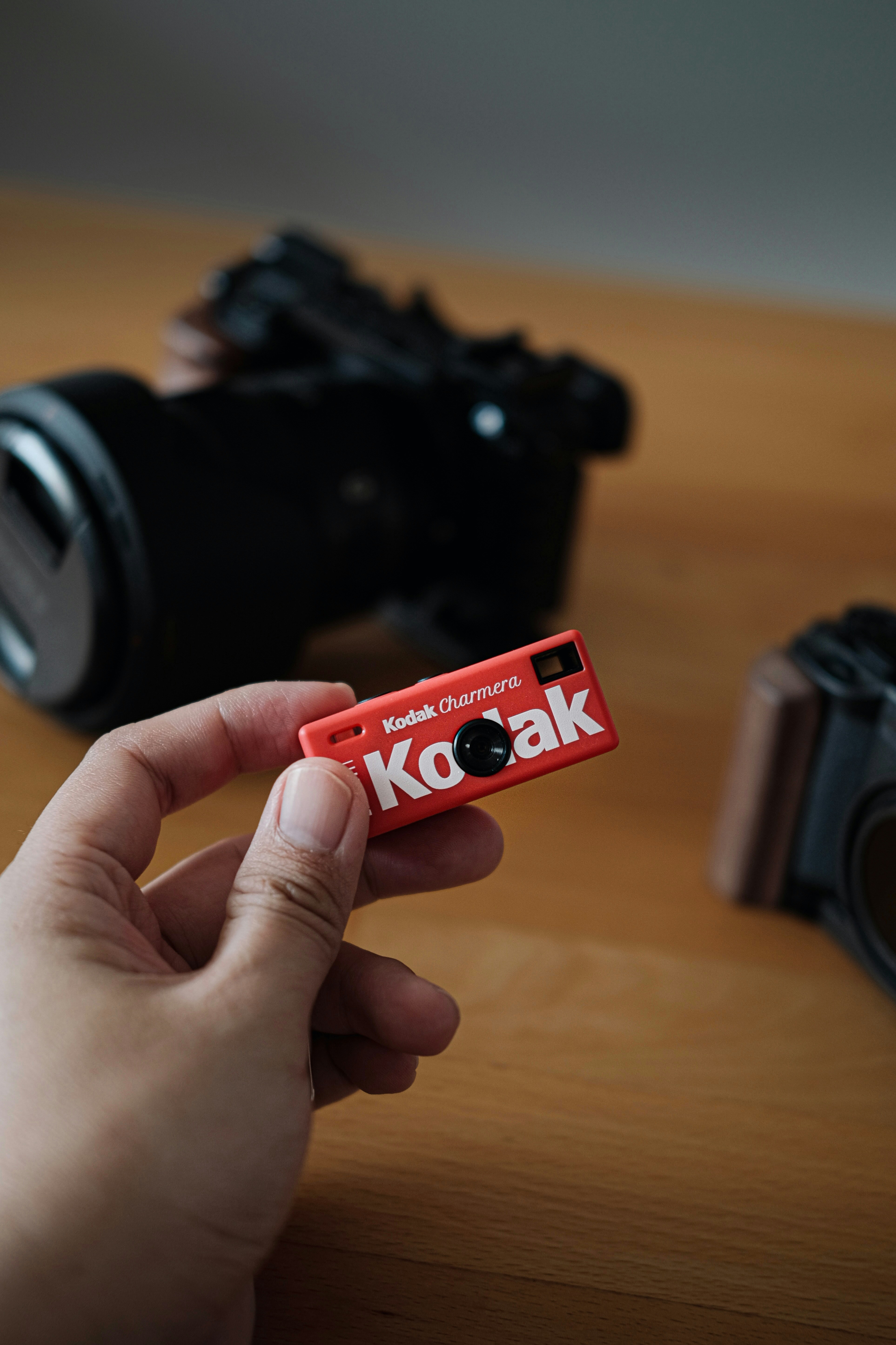 Hand holding a small red kodak camera