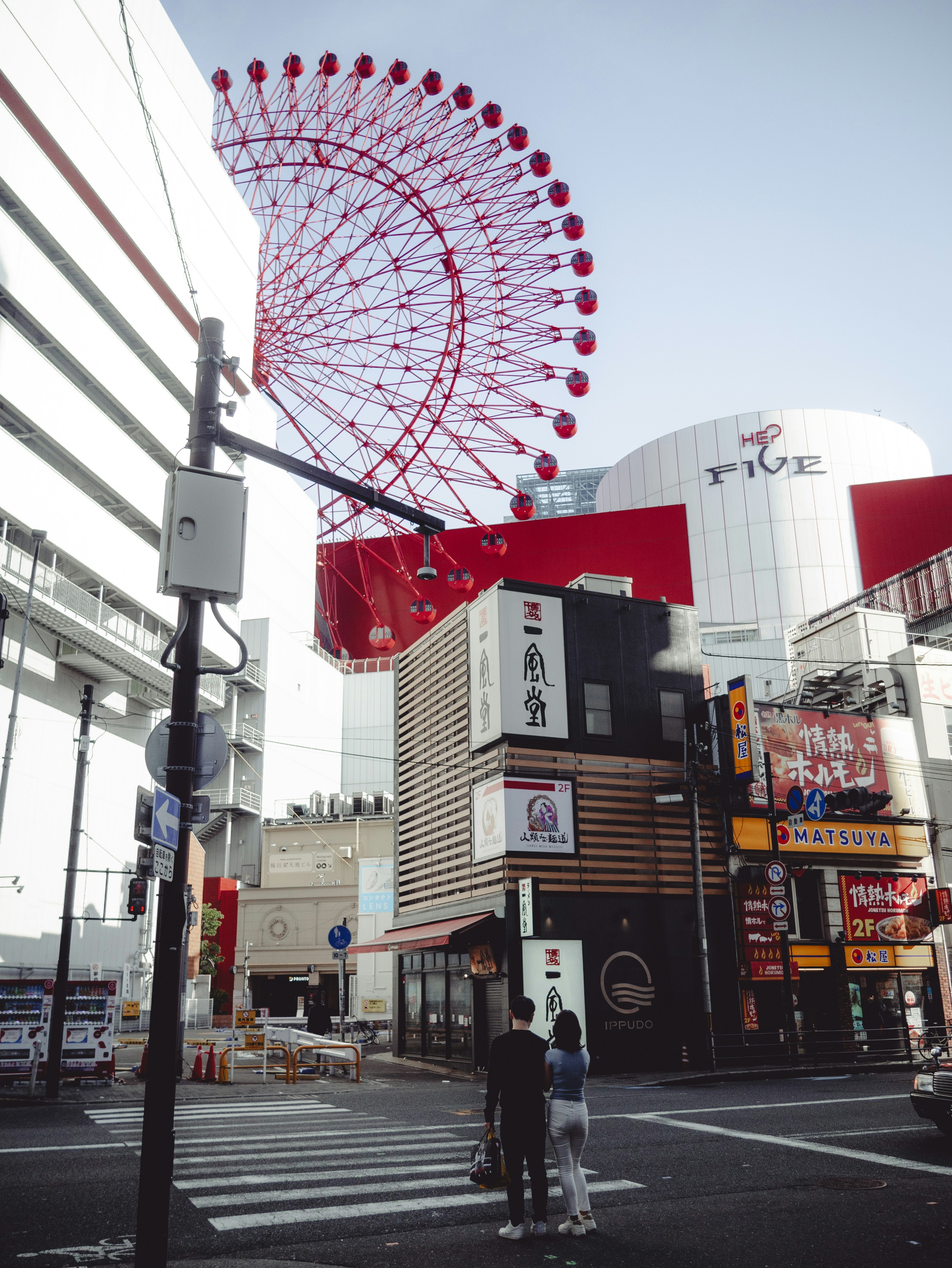 Ferris wheel above a bustling city street.