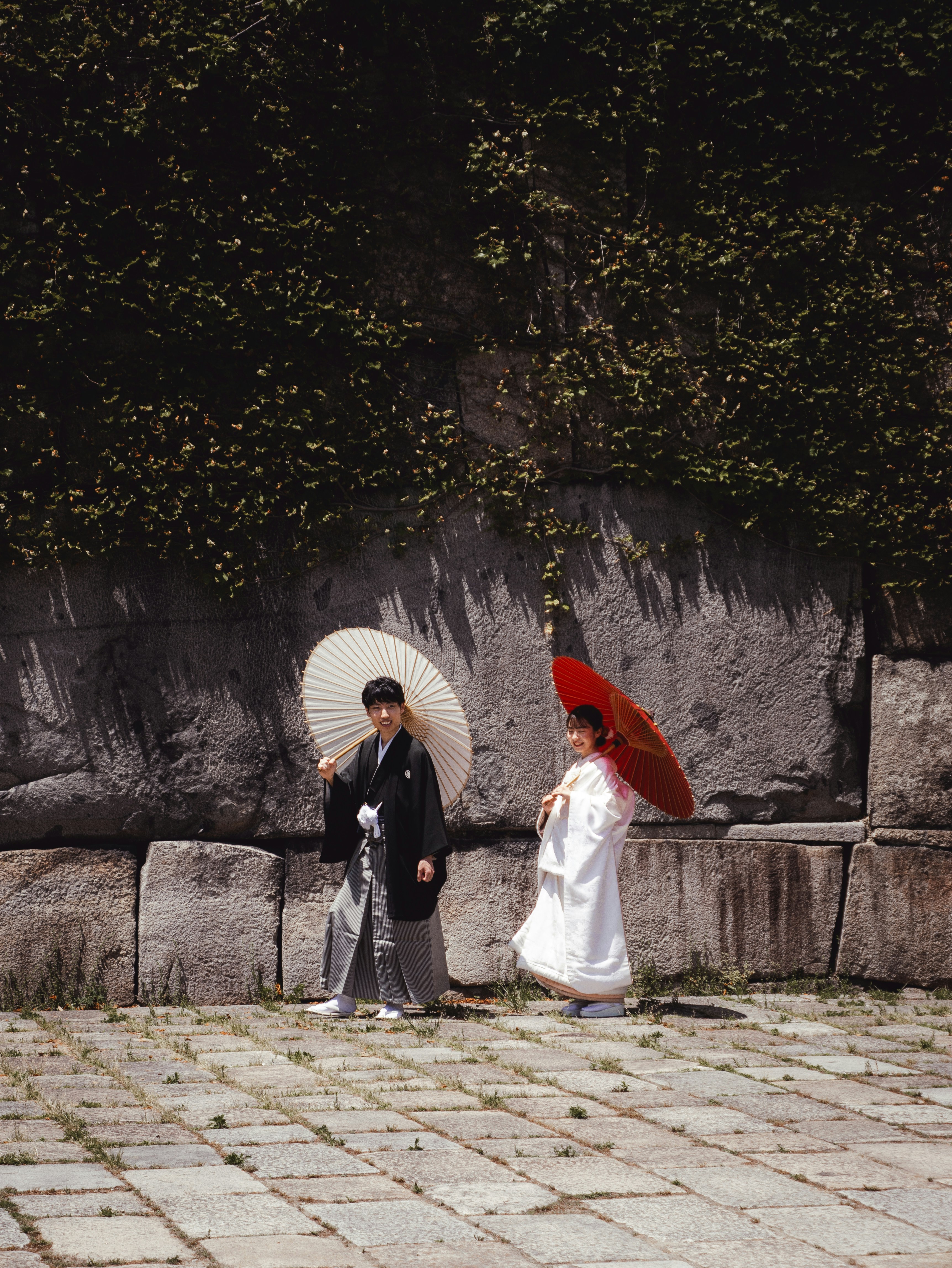 Couple in traditional japanese wedding attire with umbrellas