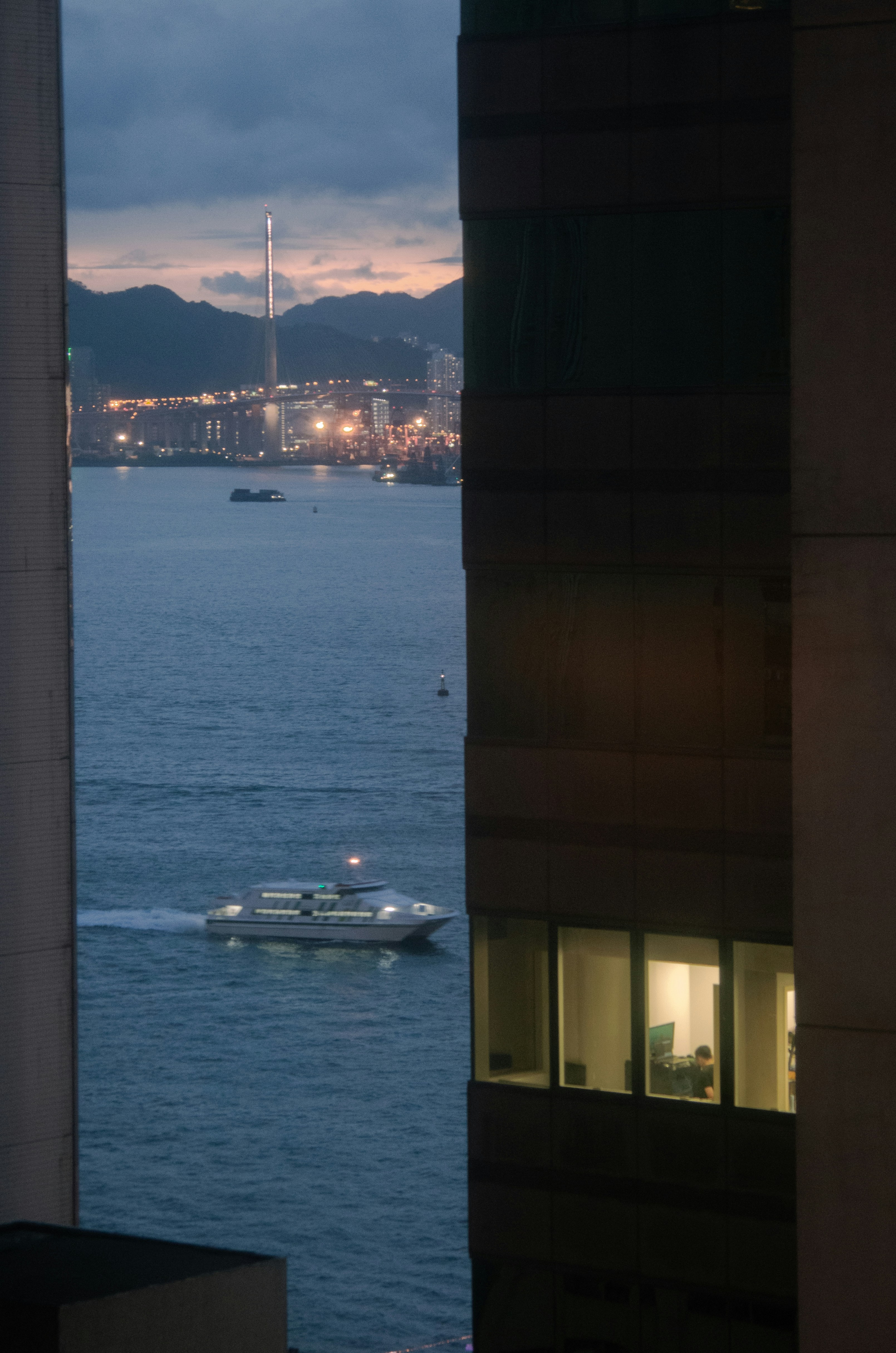 Ferry on water with city lights at dusk