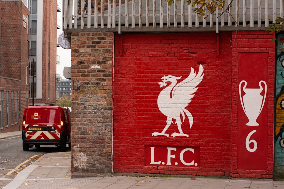 Escudo do Liverpool FC pintado numa parede de tijolo vermelho