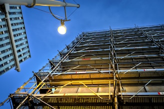 Scaffolding on building against a dark blue sky.
