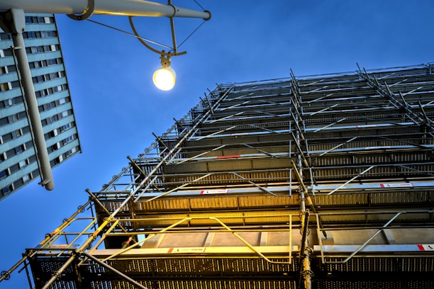 Scaffolding on building against a dark blue sky.