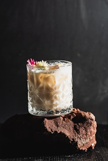 Creamy cocktail with flowers and cinnamon stick garnish