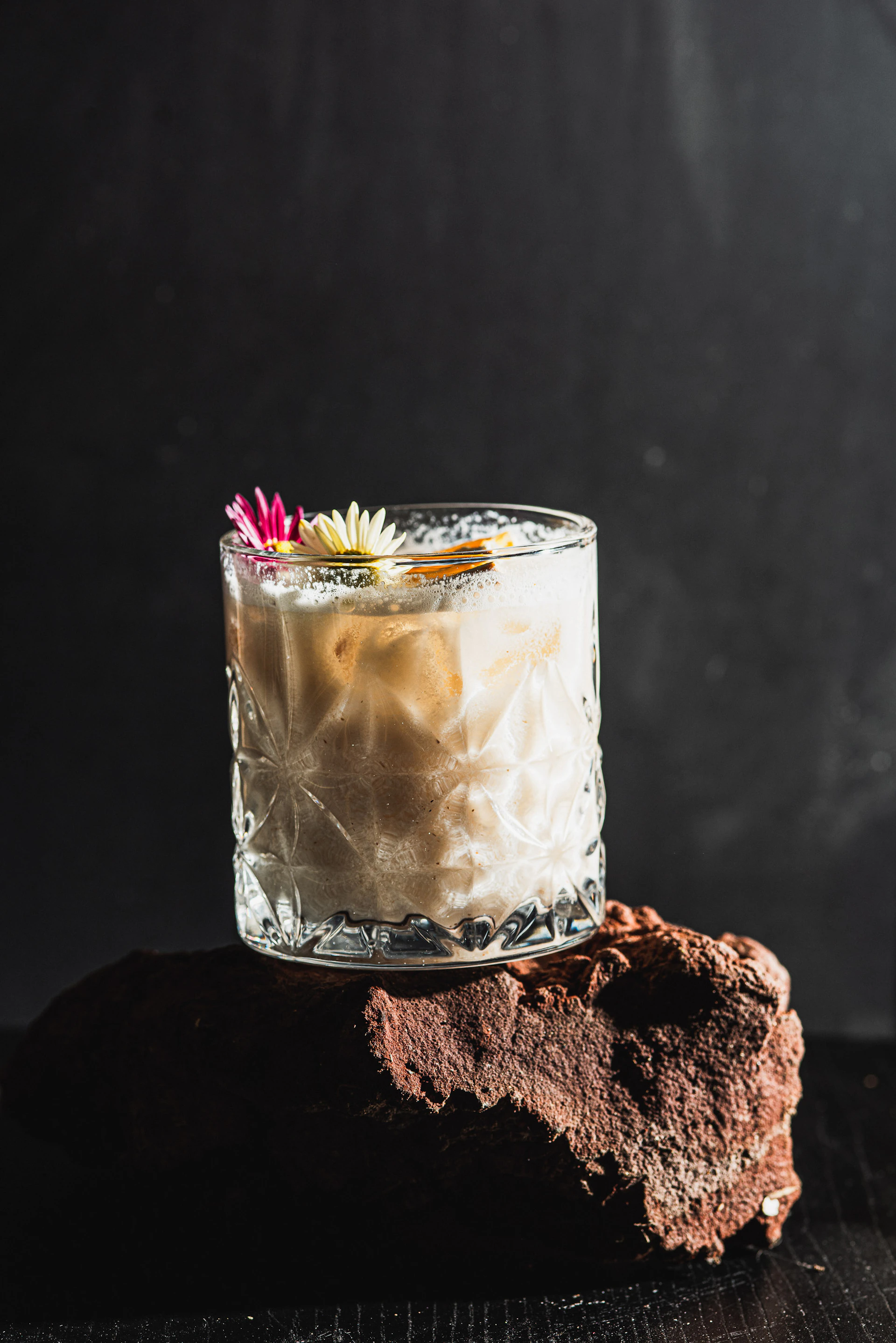 Creamy cocktail with flowers and cinnamon stick garnish