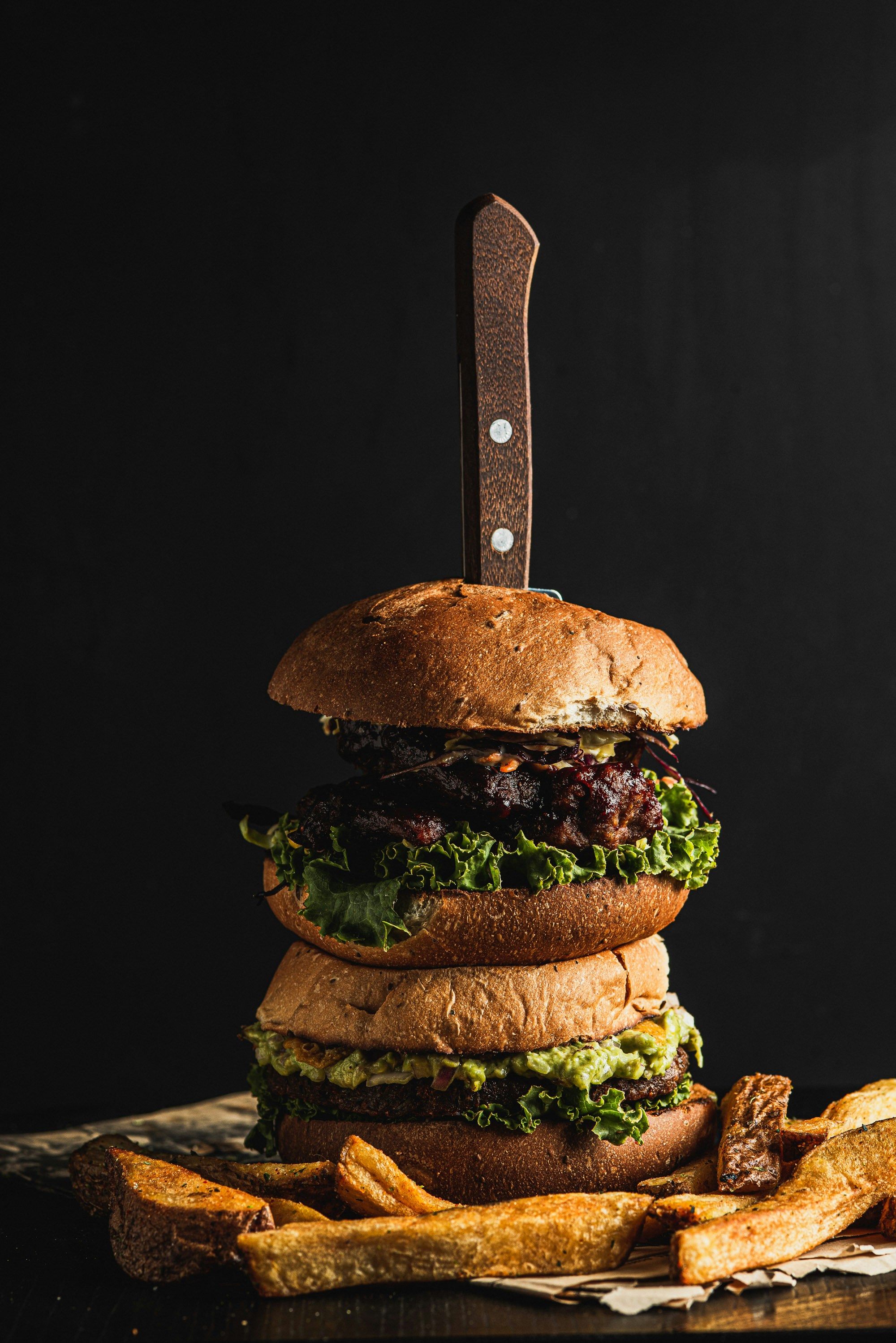 Stack of two gourmet burgers with fries