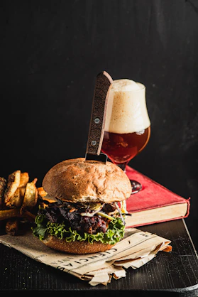Juicy burger with fries and a glass of beer.