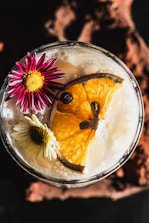 Cocktail garnished with orange slice and flowers