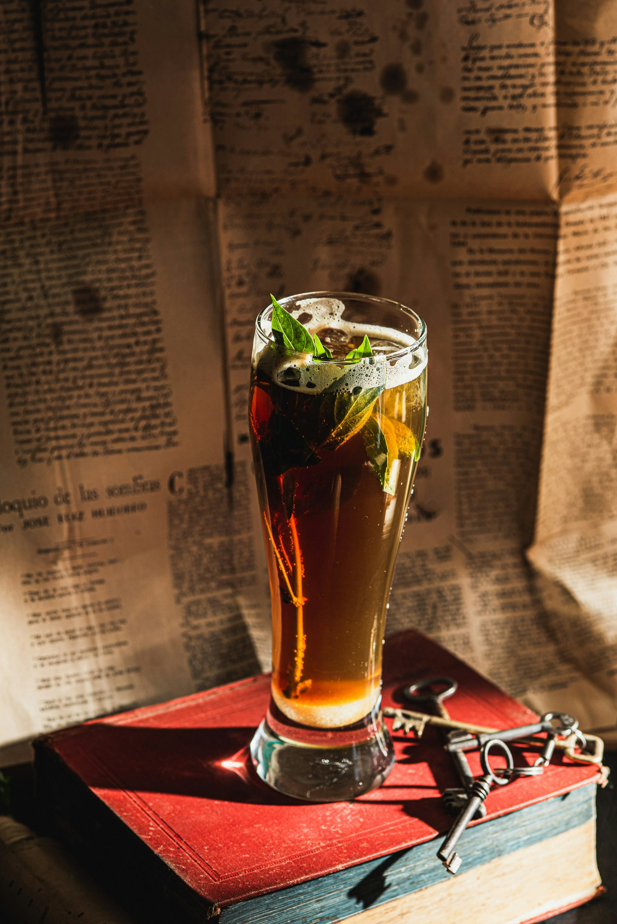 Un vaso alto de té helado con menta en los libros