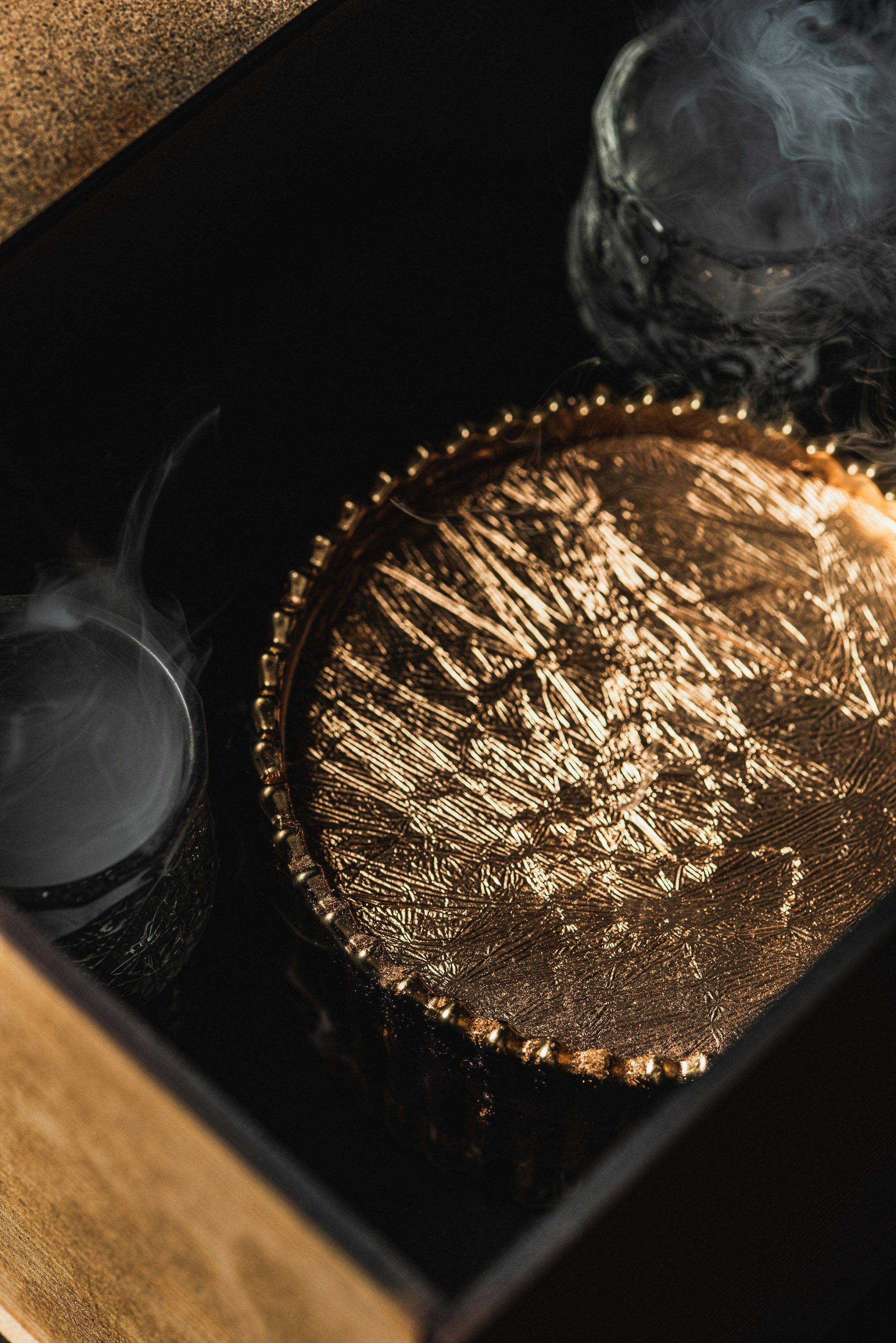 A golden tray with smoky glasses inside glasses
