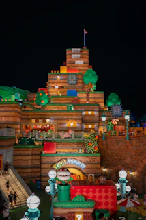 Mario themed castle structure at night with lights