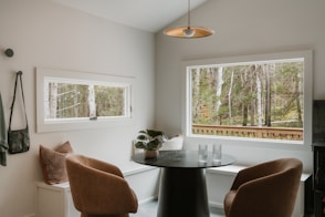 Cozy dining nook with window view of forest.