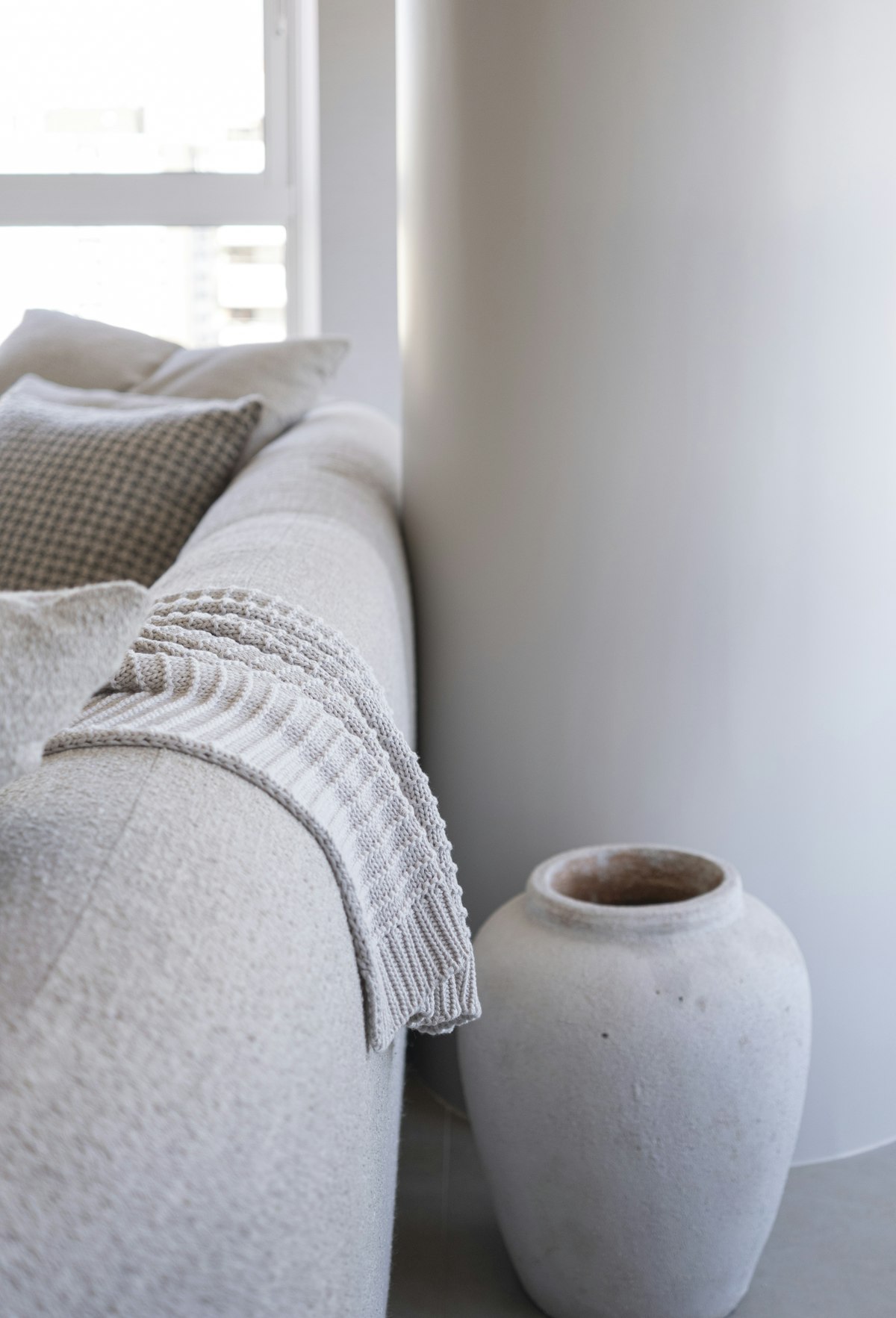 Sofa mit Strickdecke und Steingutvase – Material und Verarbeitung
