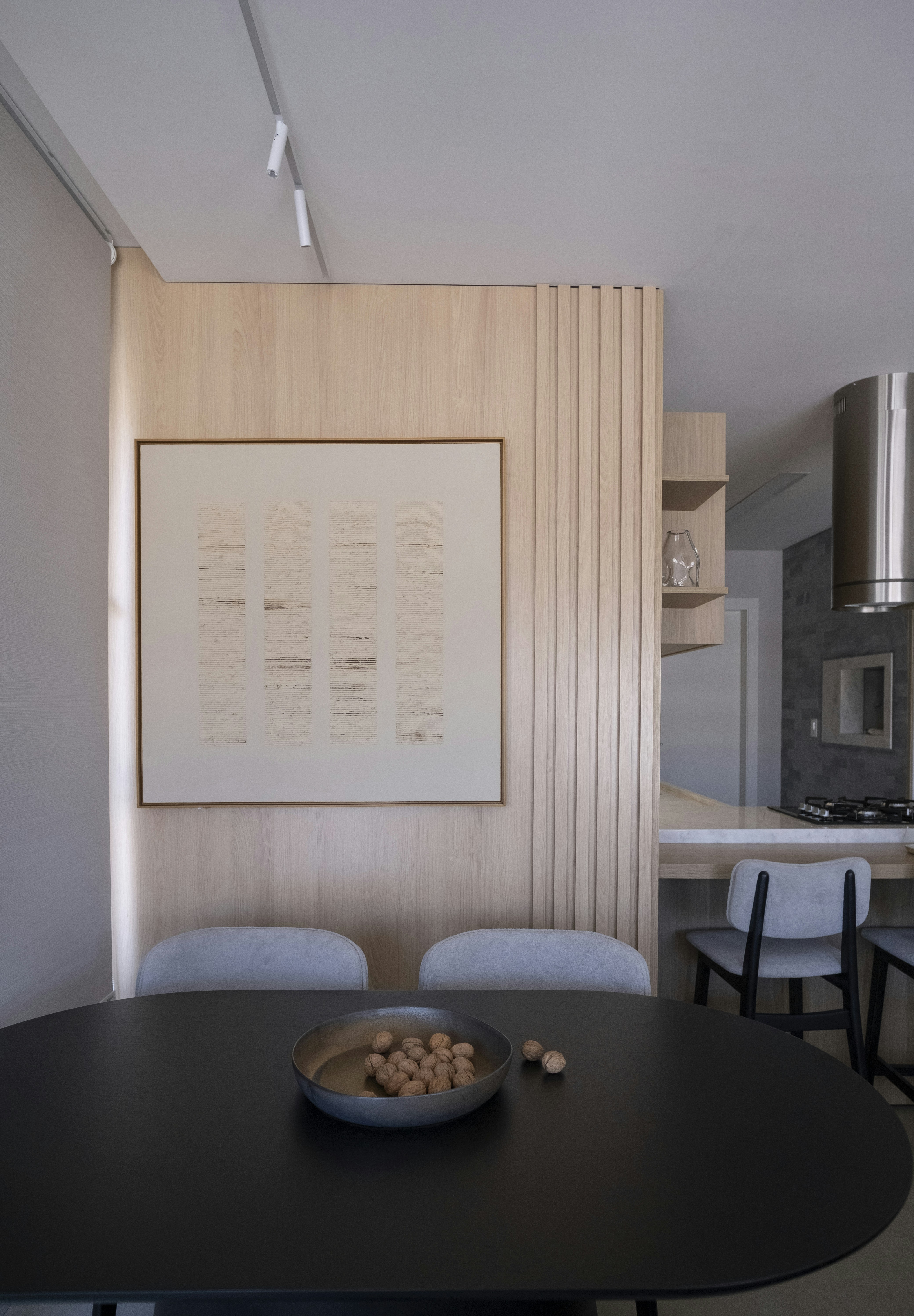 Modern dining area with artwork and pendant lights.