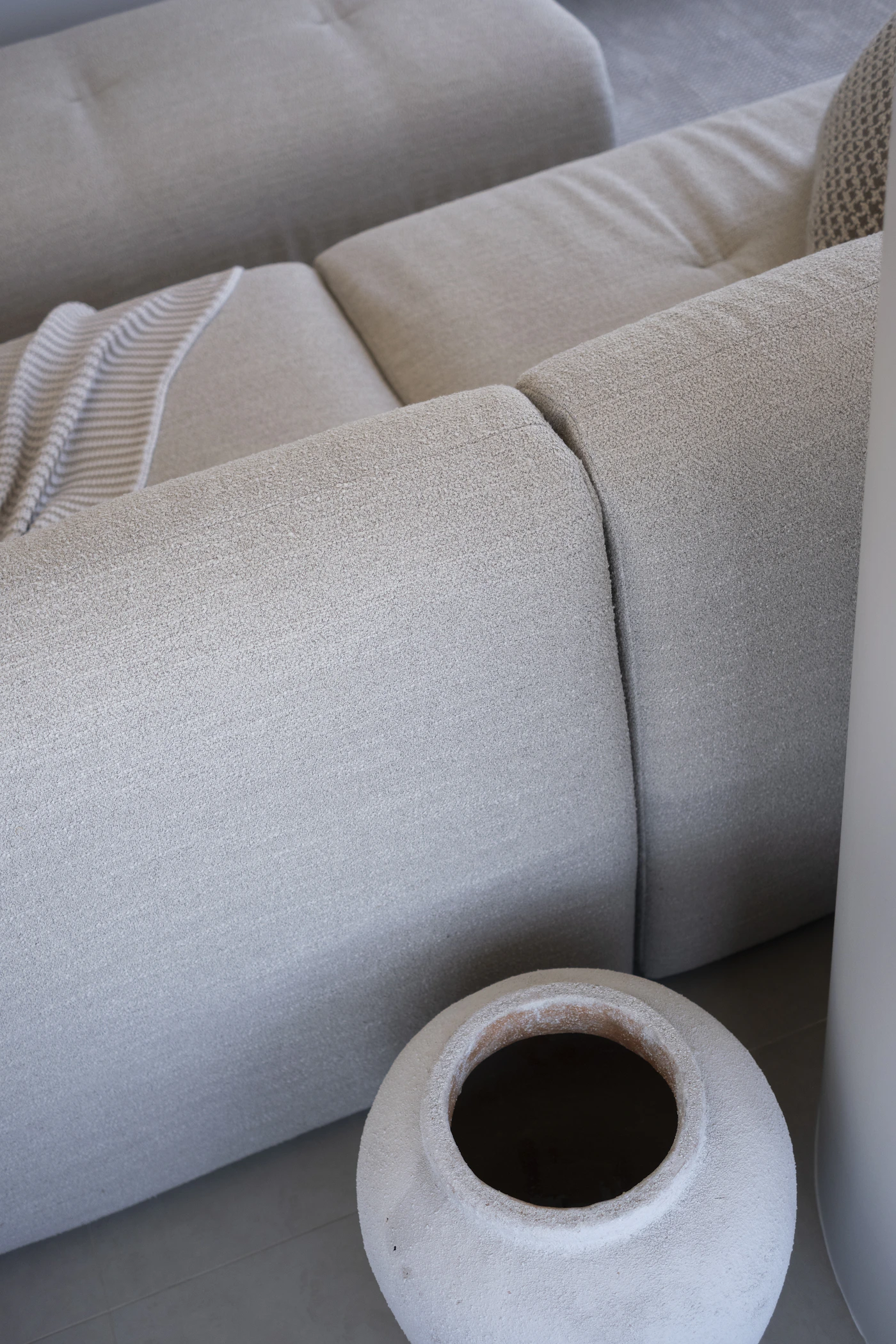 Neutral-toned contemporary sofa with textured upholstery and a soft throw in a residential living room