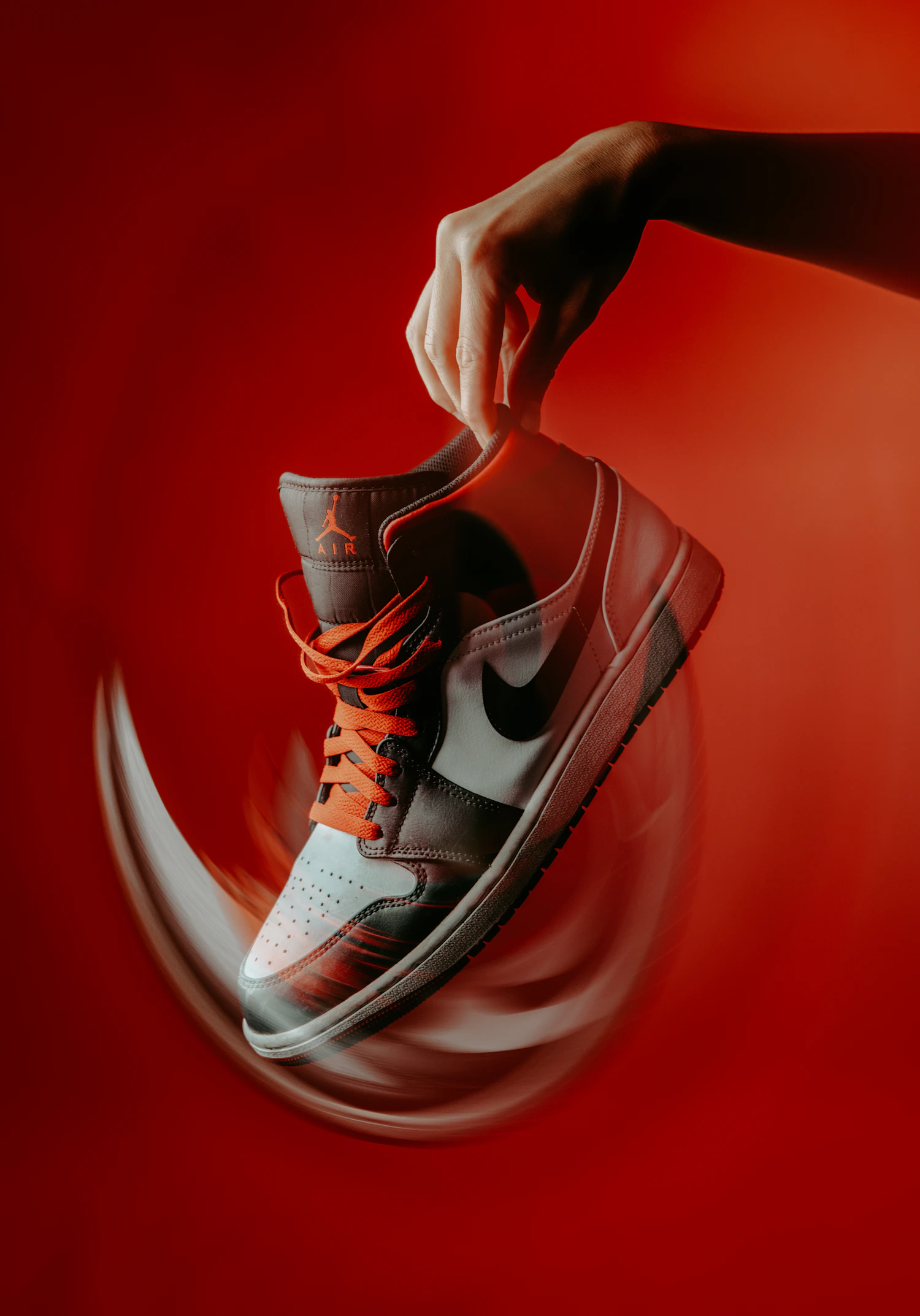 Hand spinning a red and white high-top against a red ground