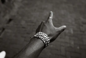 A hand with a bracelet points upwards