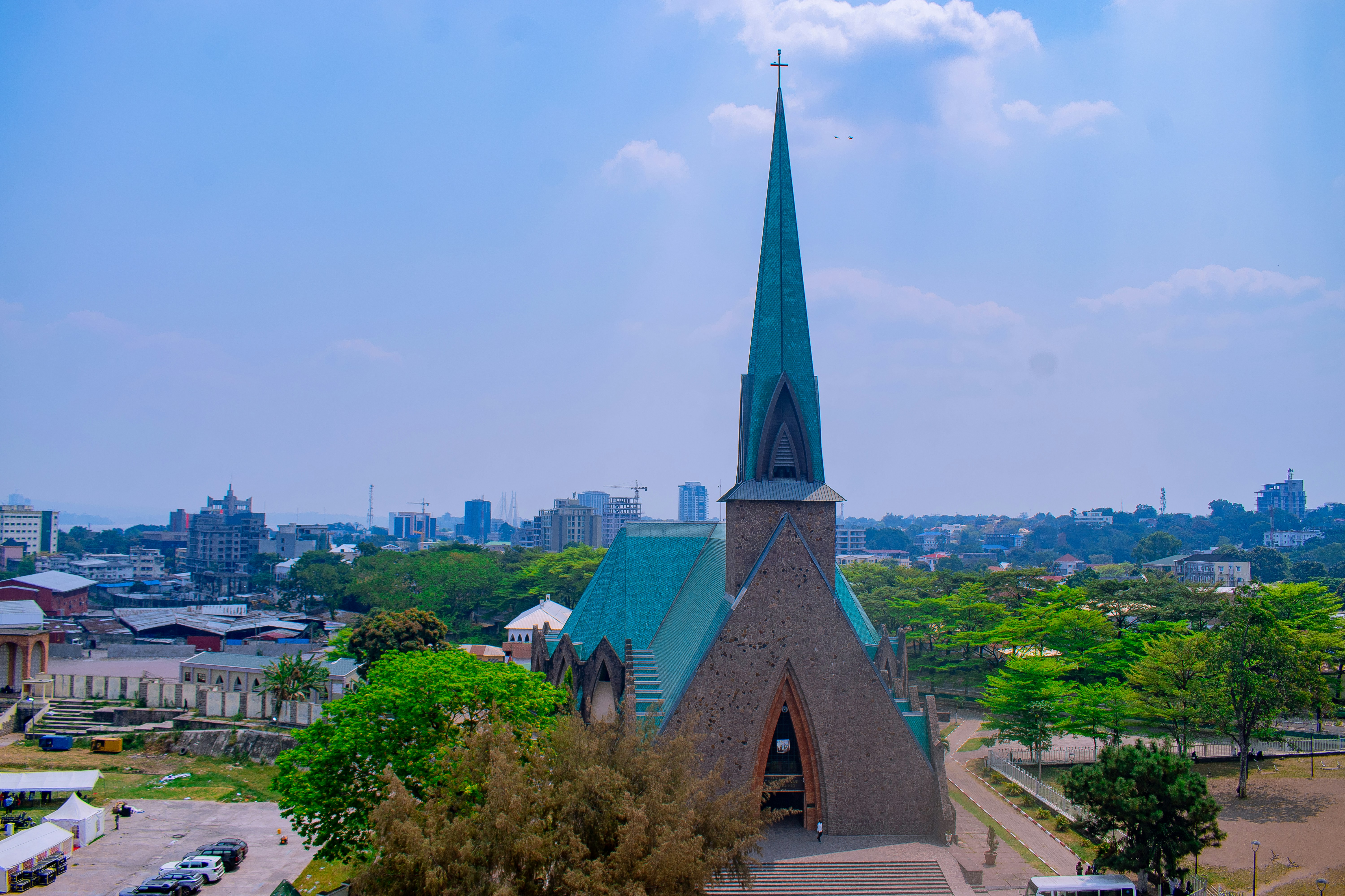 A church with a tall steeple and green roof.