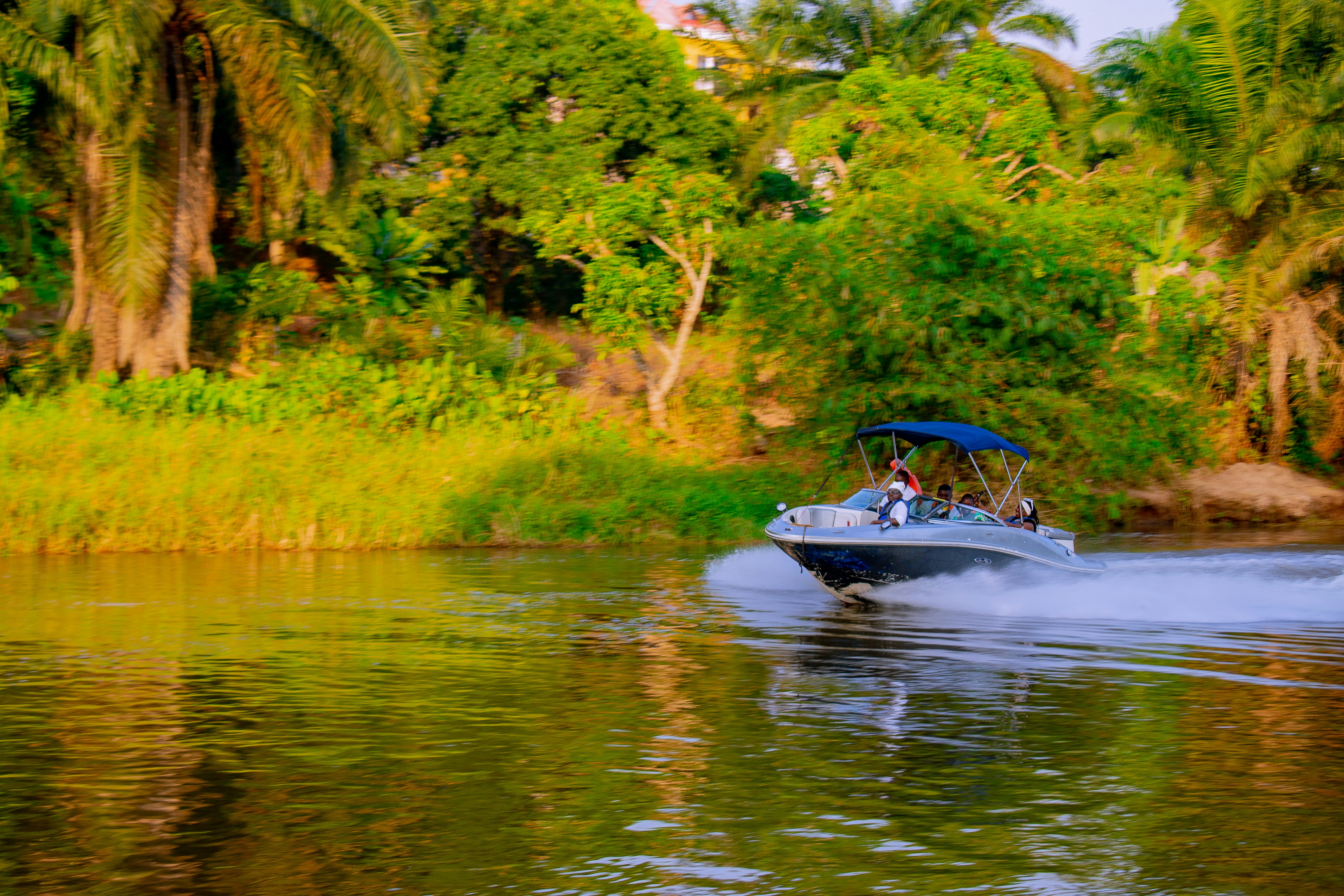 A boat cruises down a wide, calm river.