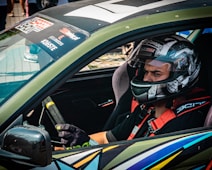 A race car driver wearing a helmet and gloves.