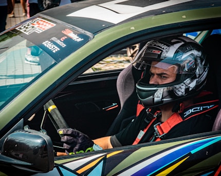 A race car driver wearing a helmet and gloves.