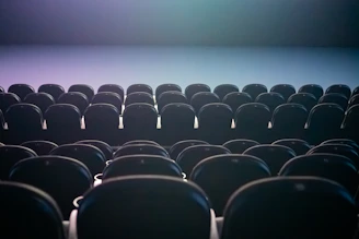 Rows of empty theater seats with colored lighting.
