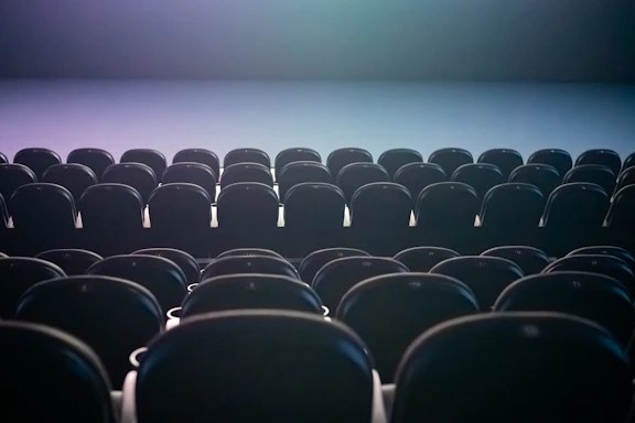Rows of empty theater seats with colored lighting.
