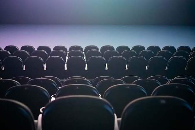 Rows of empty theater seats under colored stage lighting, similar in scale to the 2,500-seat venue approved for the ballpark district