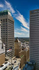 Tall buildings under a bright blue sky with clouds.