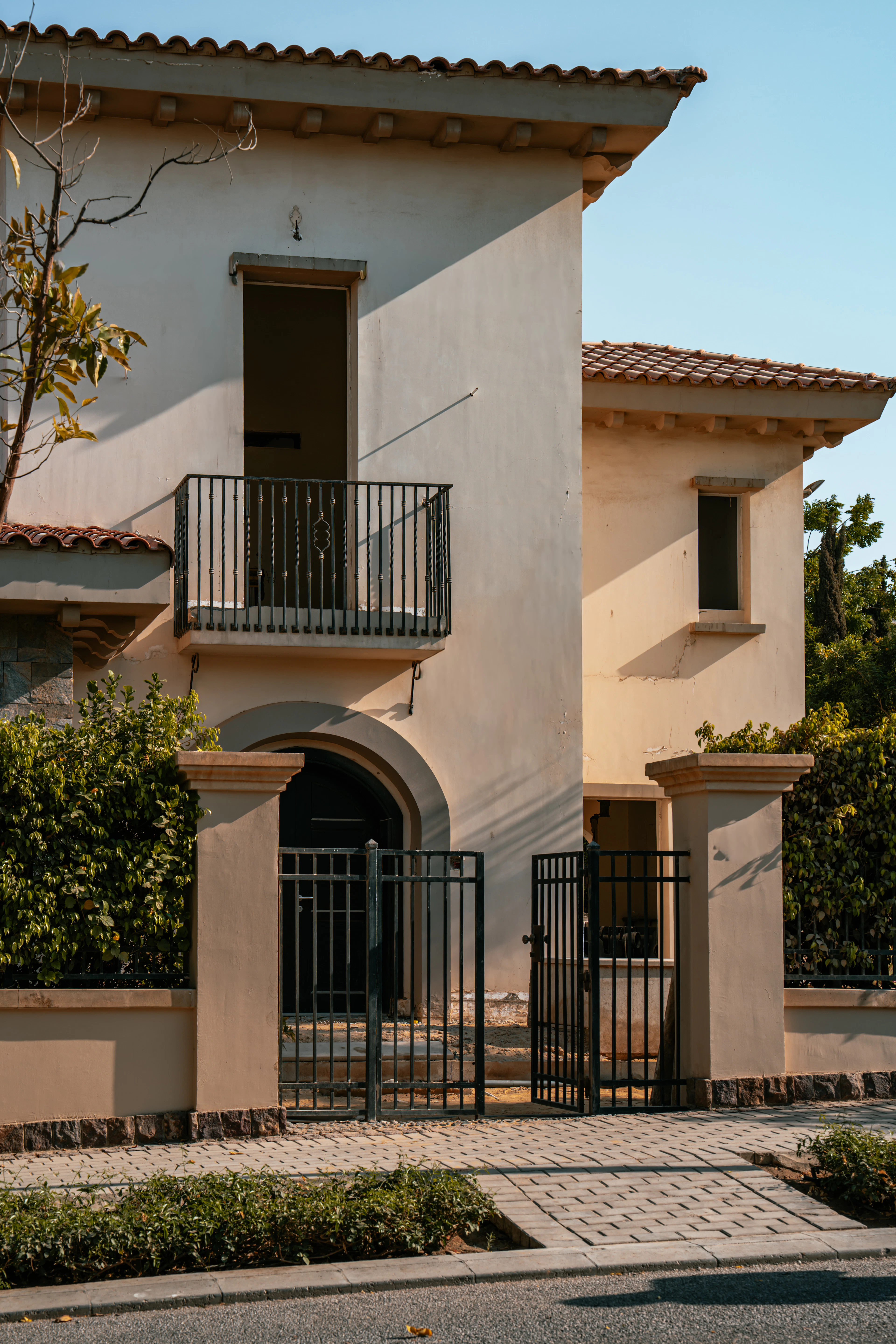 Beige villa with a balcony and front gate