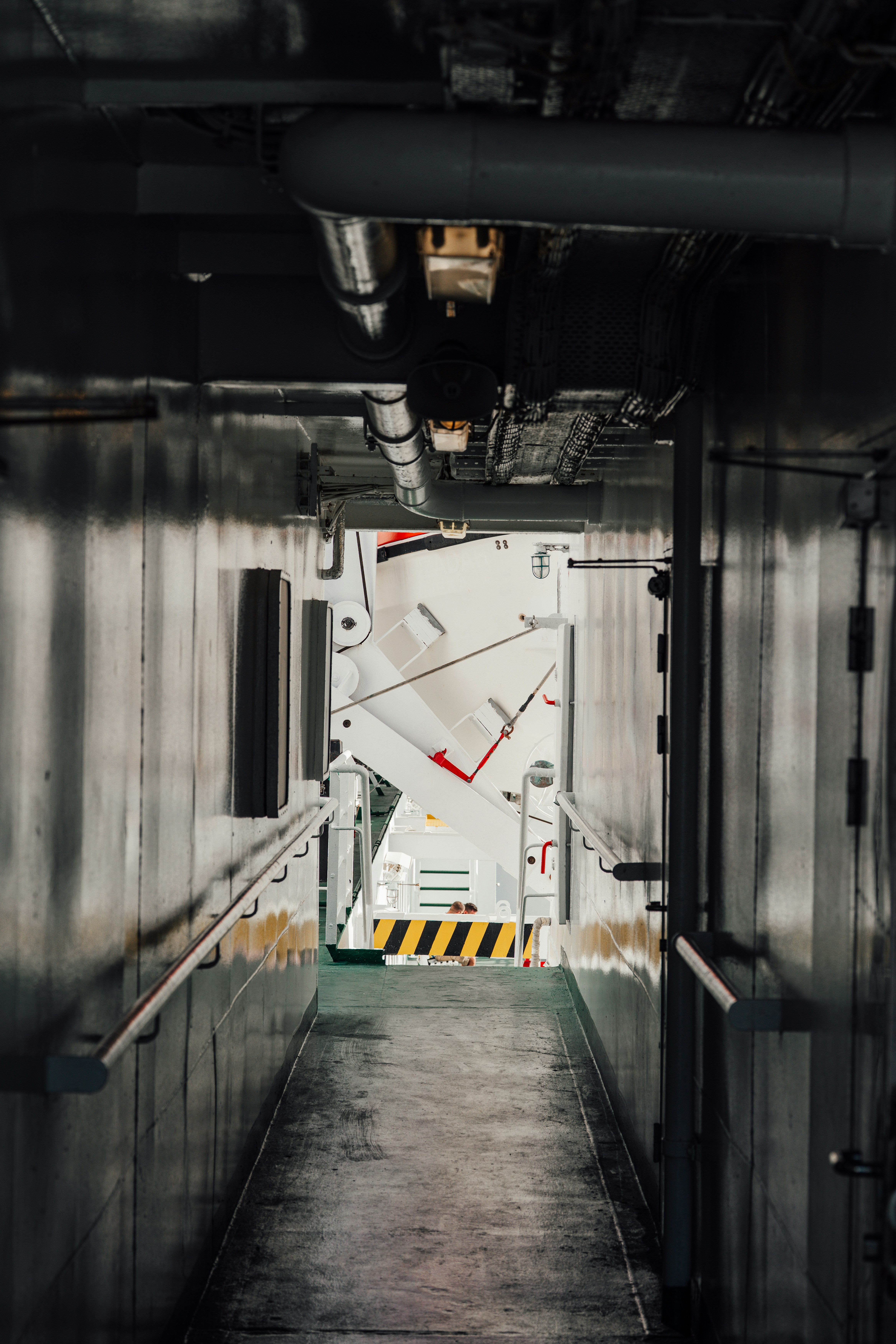 Corridoio industriale che conduce a una grande porta bianca