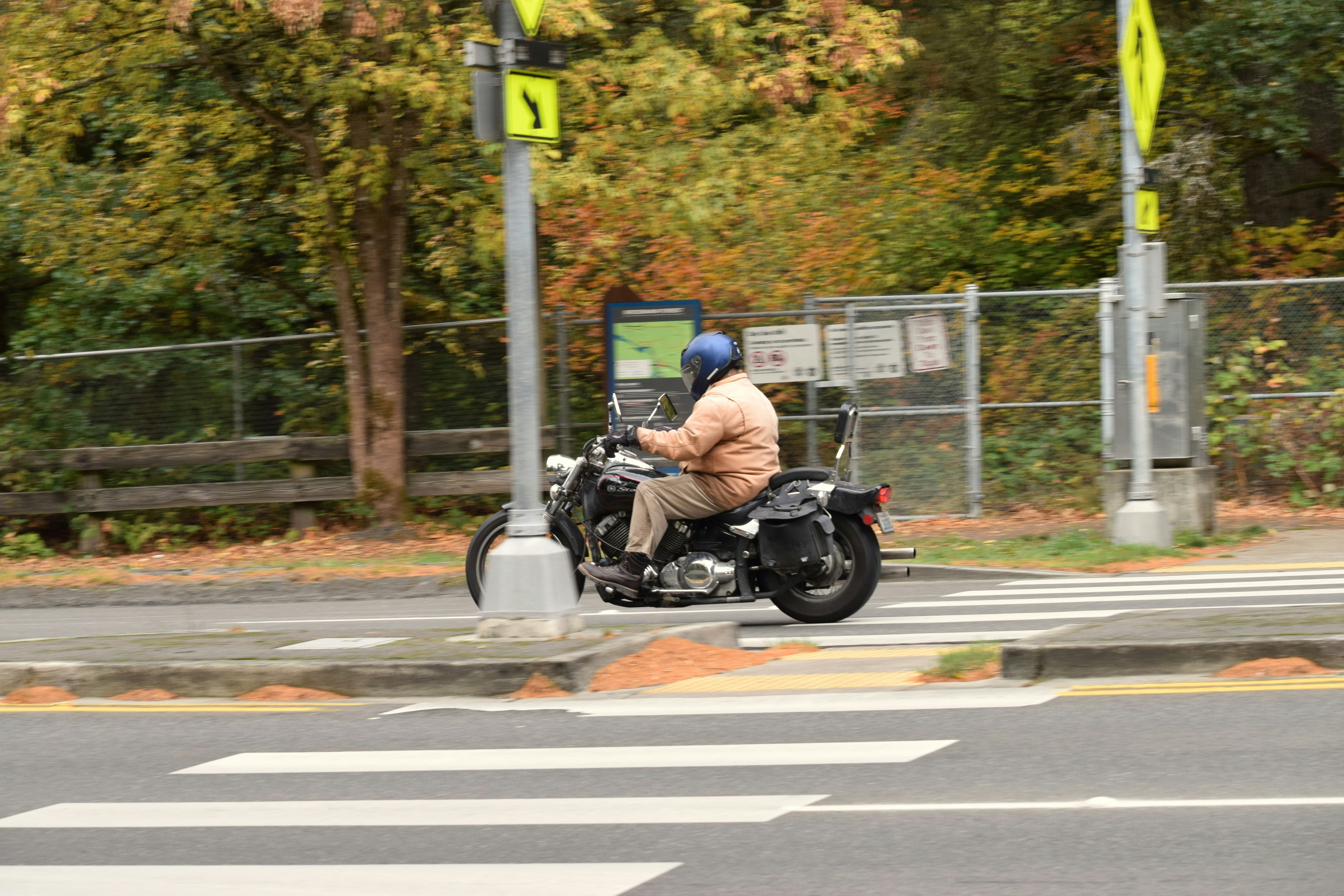 Man riding a motorcycle at a crosswalk.