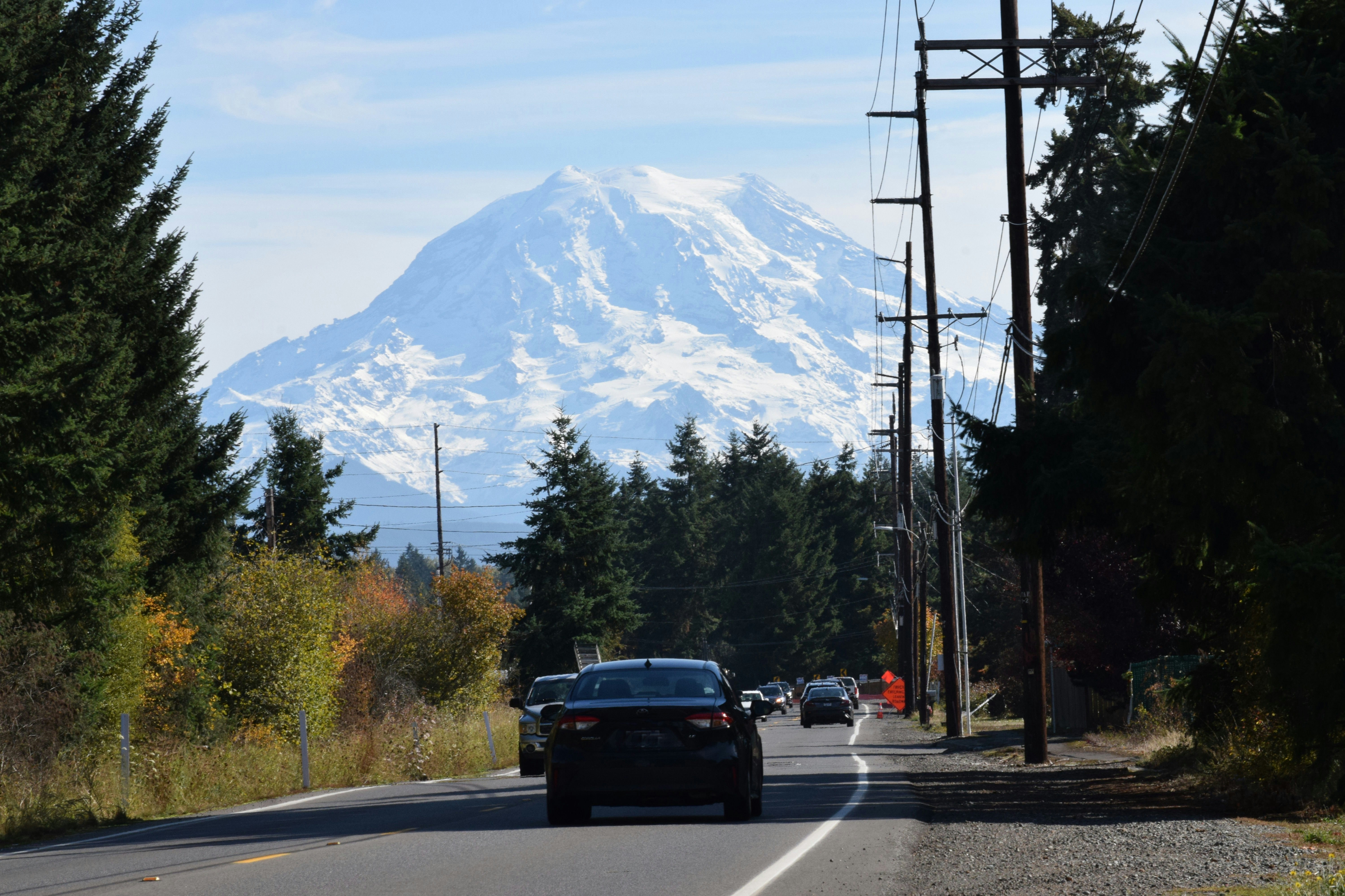 Cars on road with snow-capped mountain background