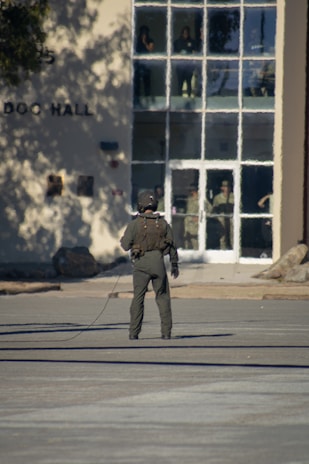 Person in uniform stands outside a building