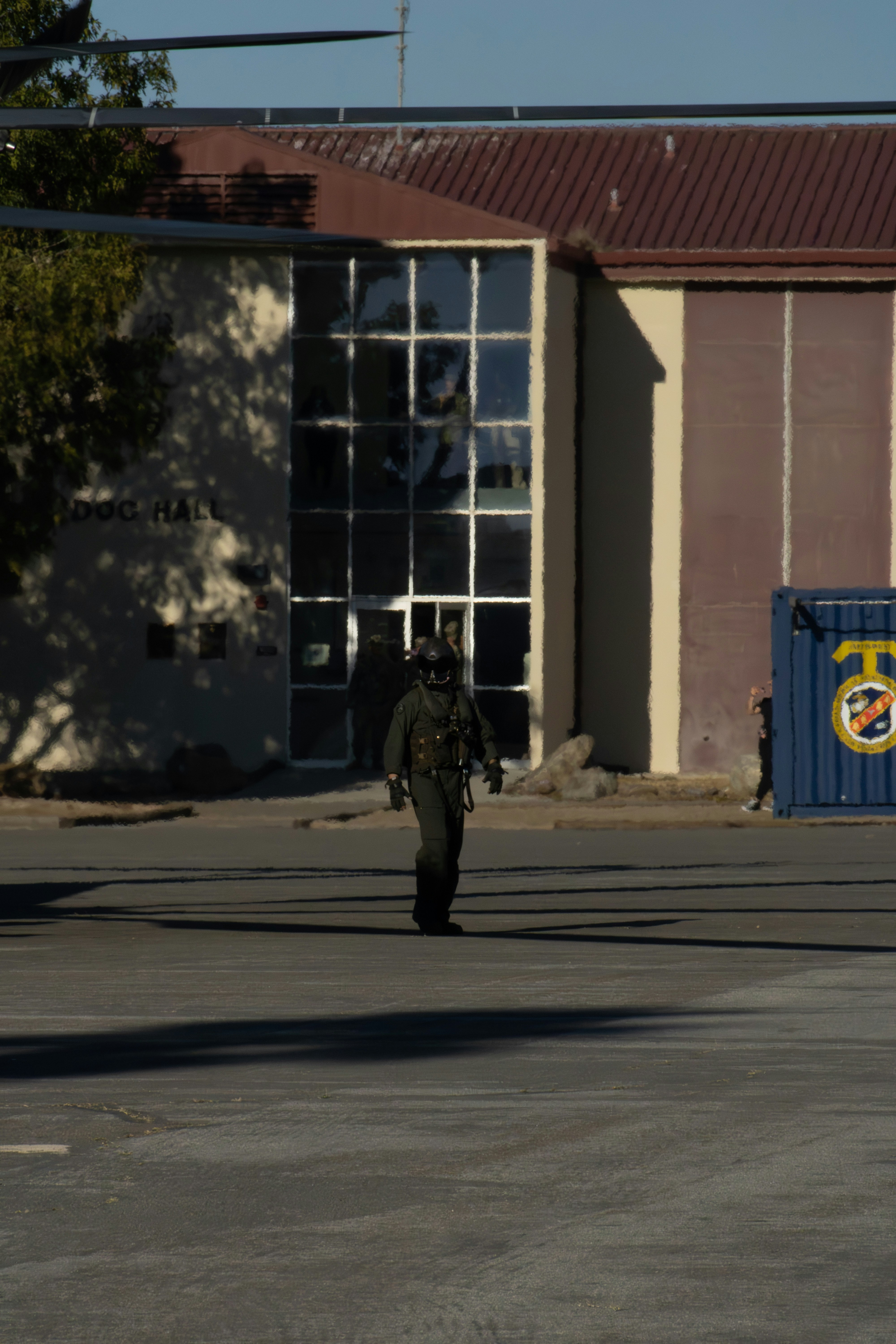 어두운 제복을 입은 사람이 건물 근처를 걷고 있습니다.