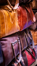 Stack of colorful leather bags in a market.