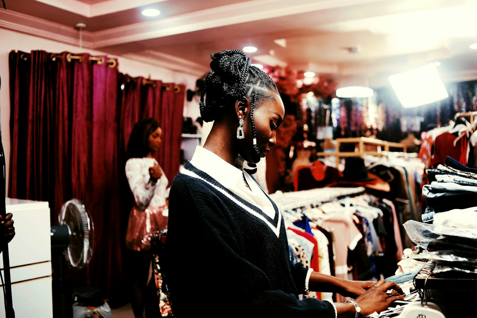 Cliente dans une boutique de vêtements, essayage avant achat en Afrique de l'Ouest