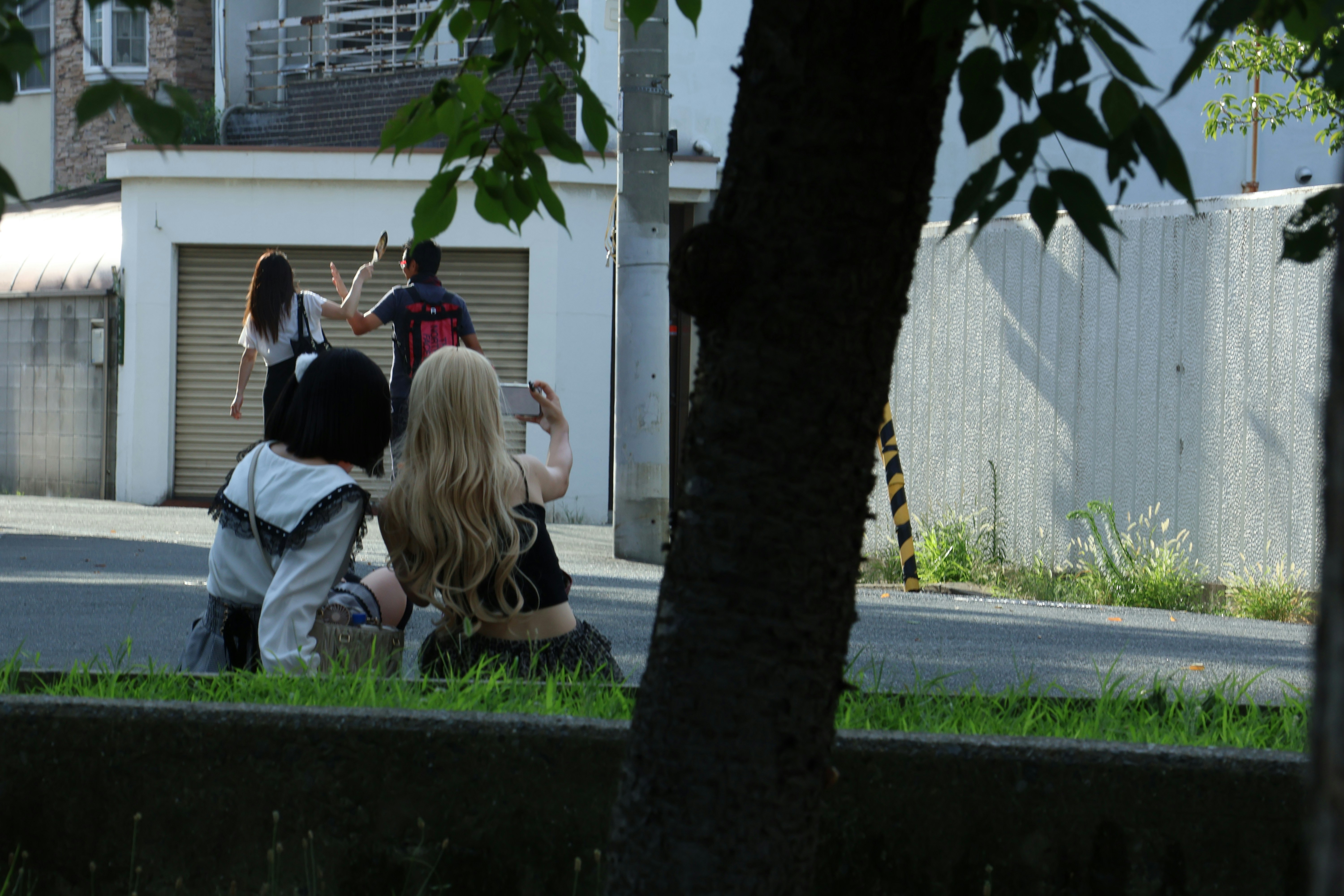 Two people taking a selfie with others in background.