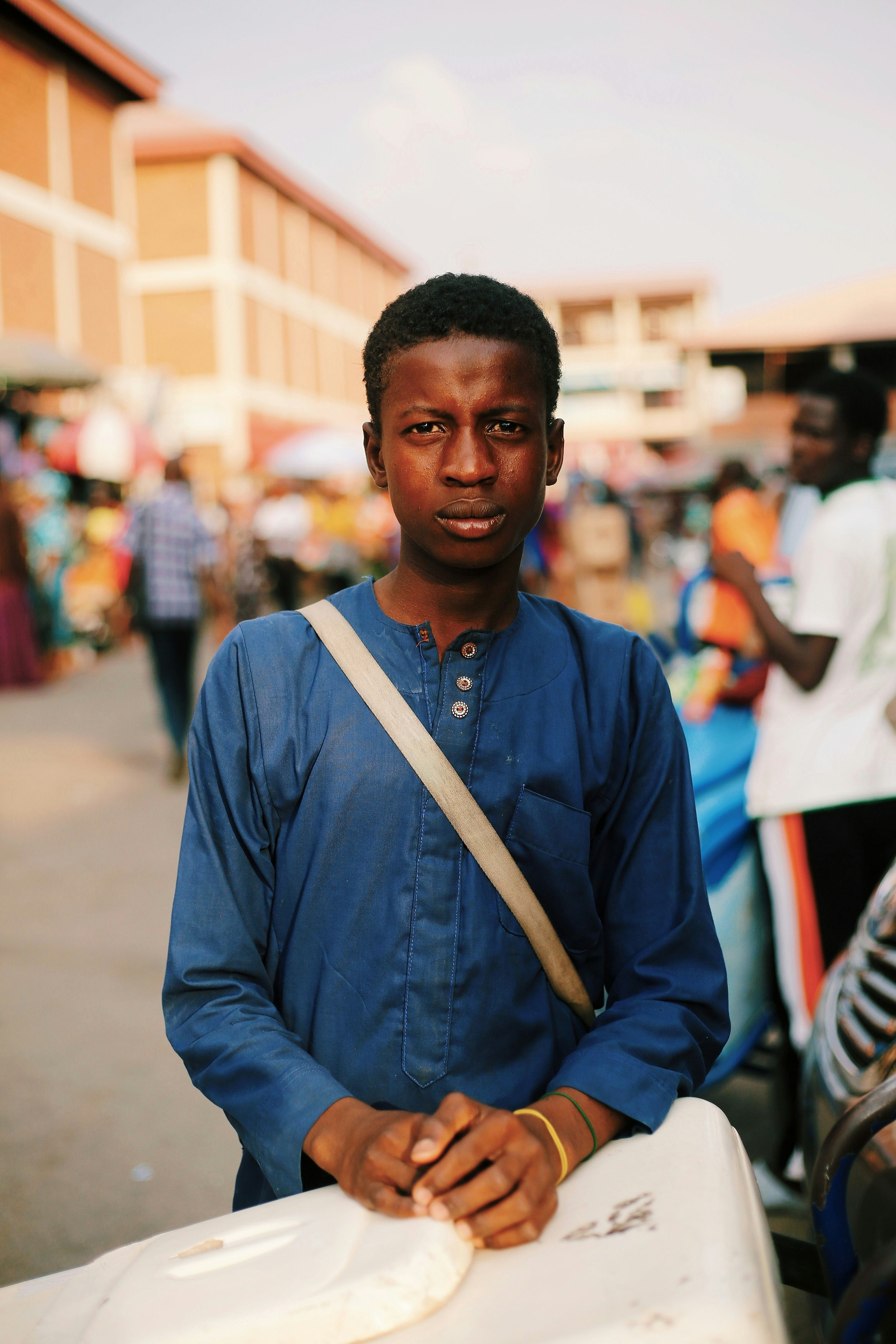 Young man in blue tunic at market