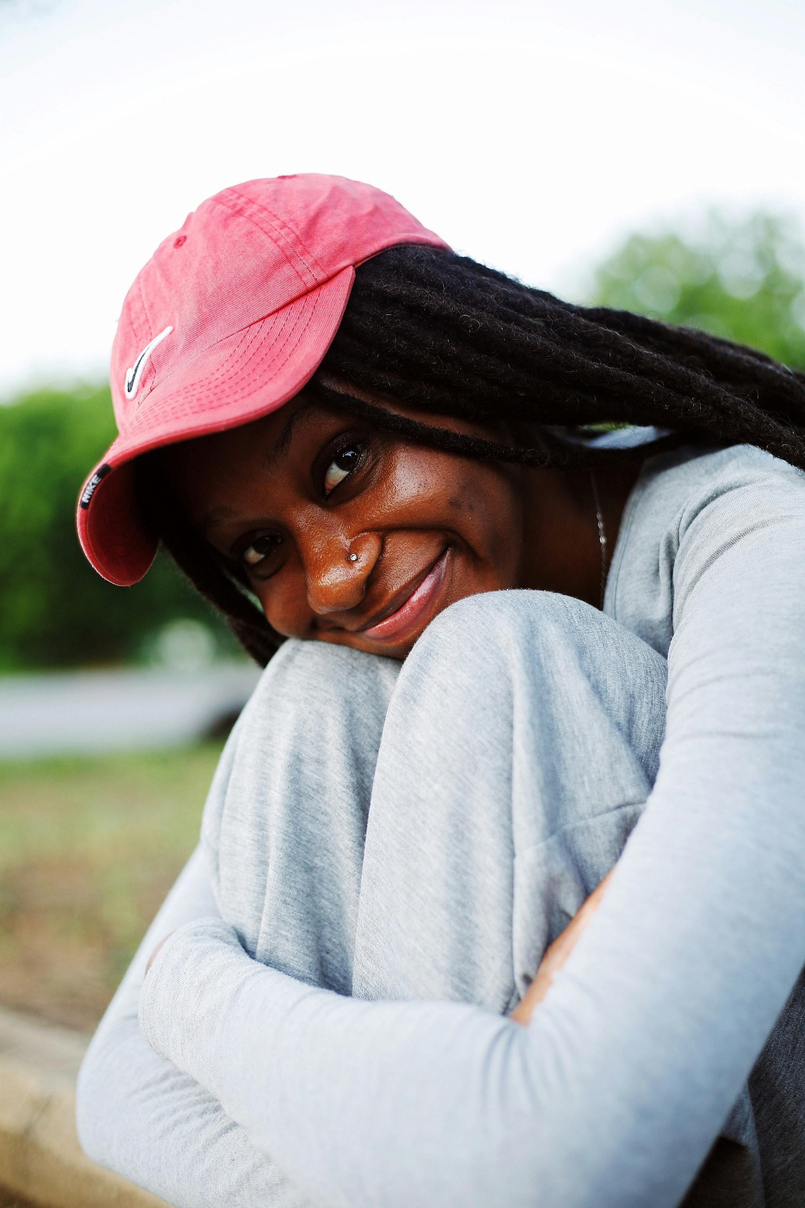 Young woman with dreadlocks wearing a red cap