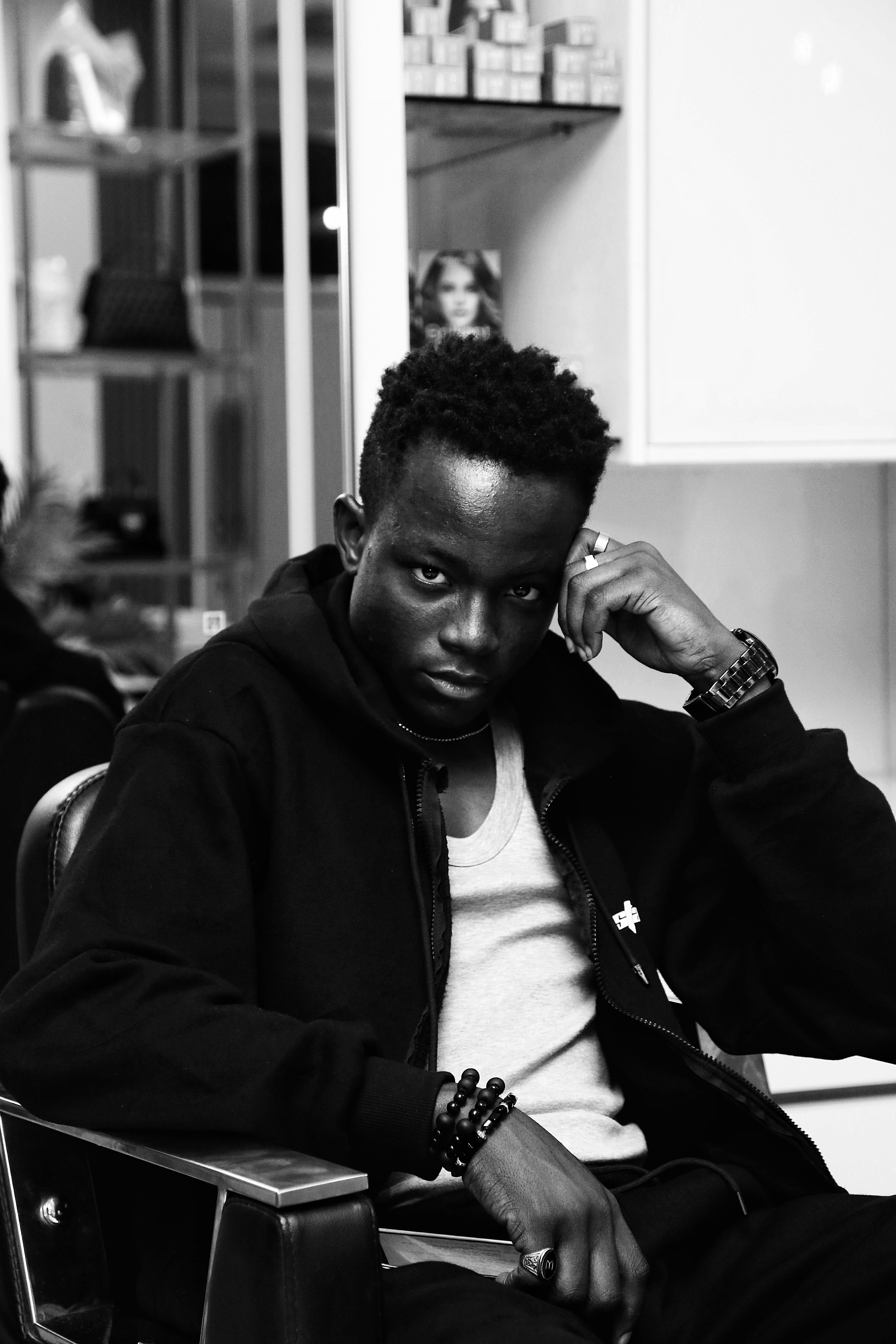 Young black man sitting looking at camera