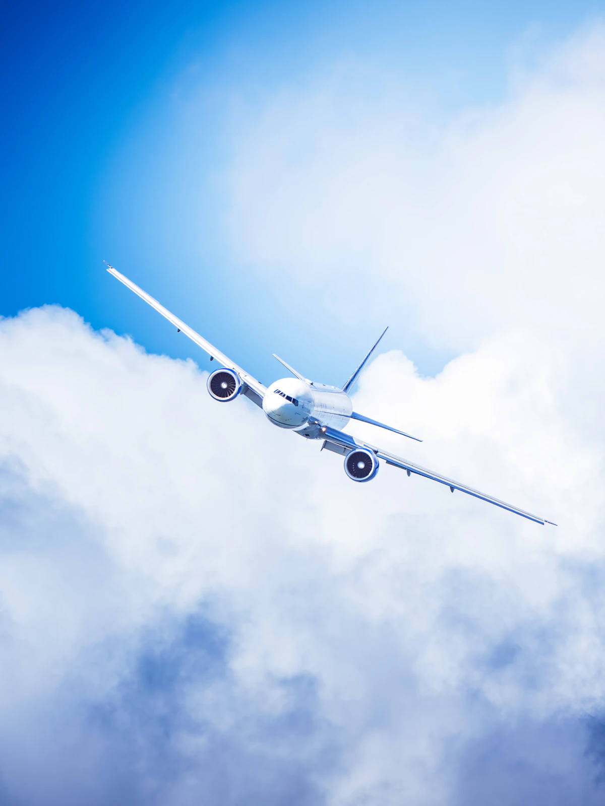 A commercial airplane flying through fluffy clouds
