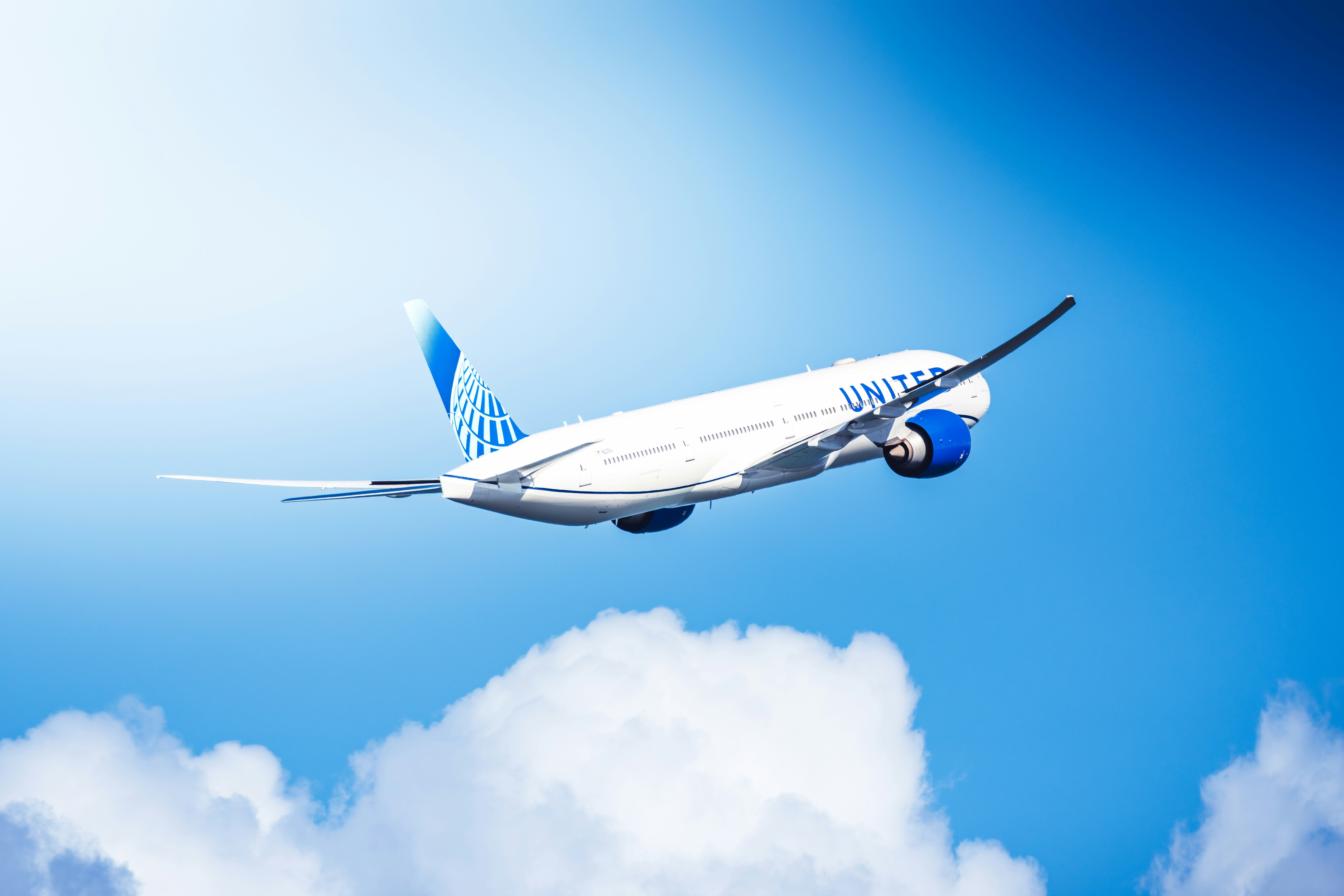 Un avión comercial volando a través de un cielo azul brillante.