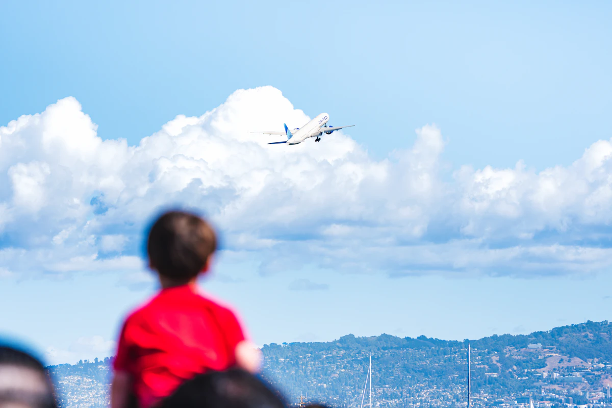 A child watching an aircraft climb into a cloudy sky, the excitement of a first trip on a private jet with kids