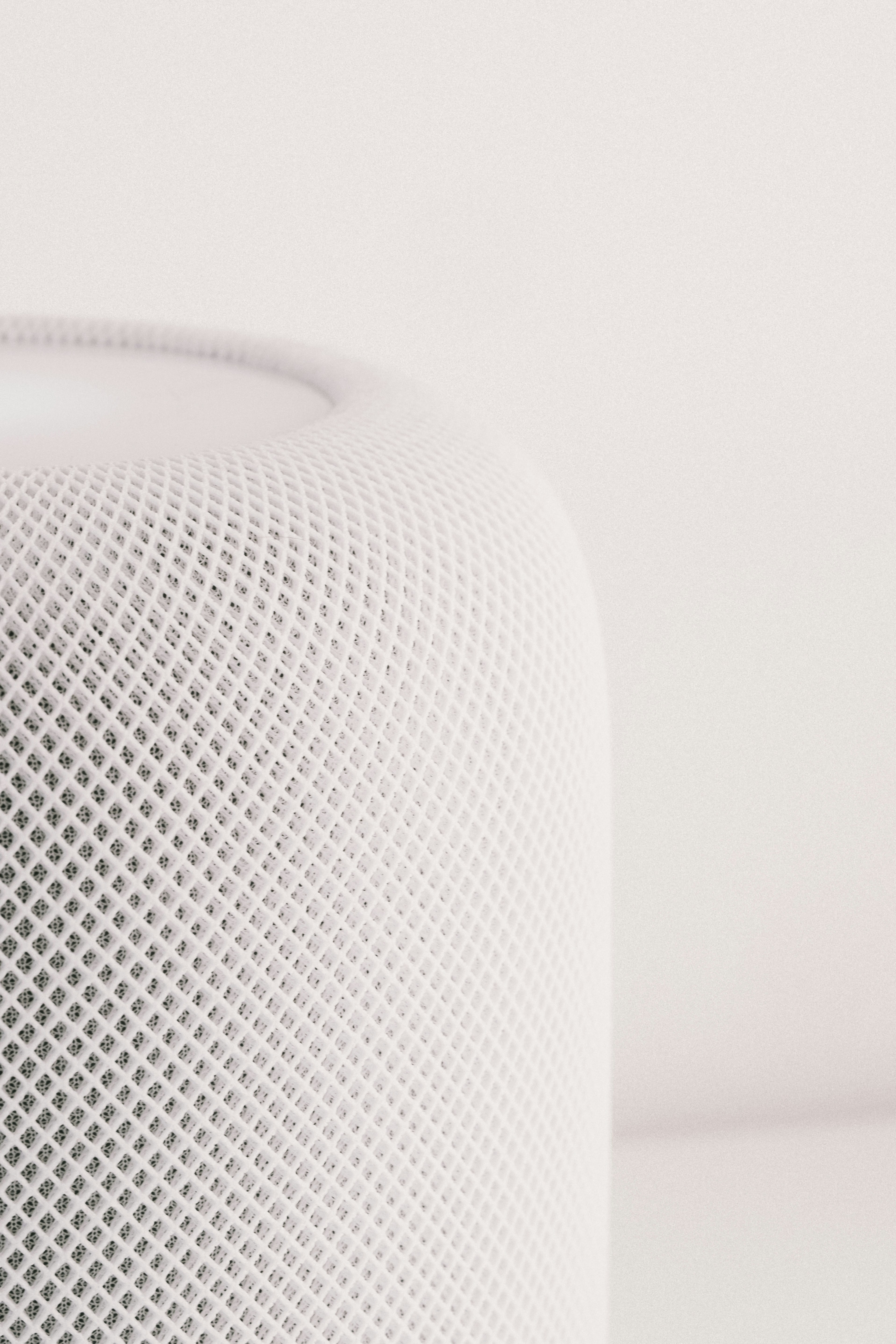Close-up of a white cylindrical speaker with mesh texture